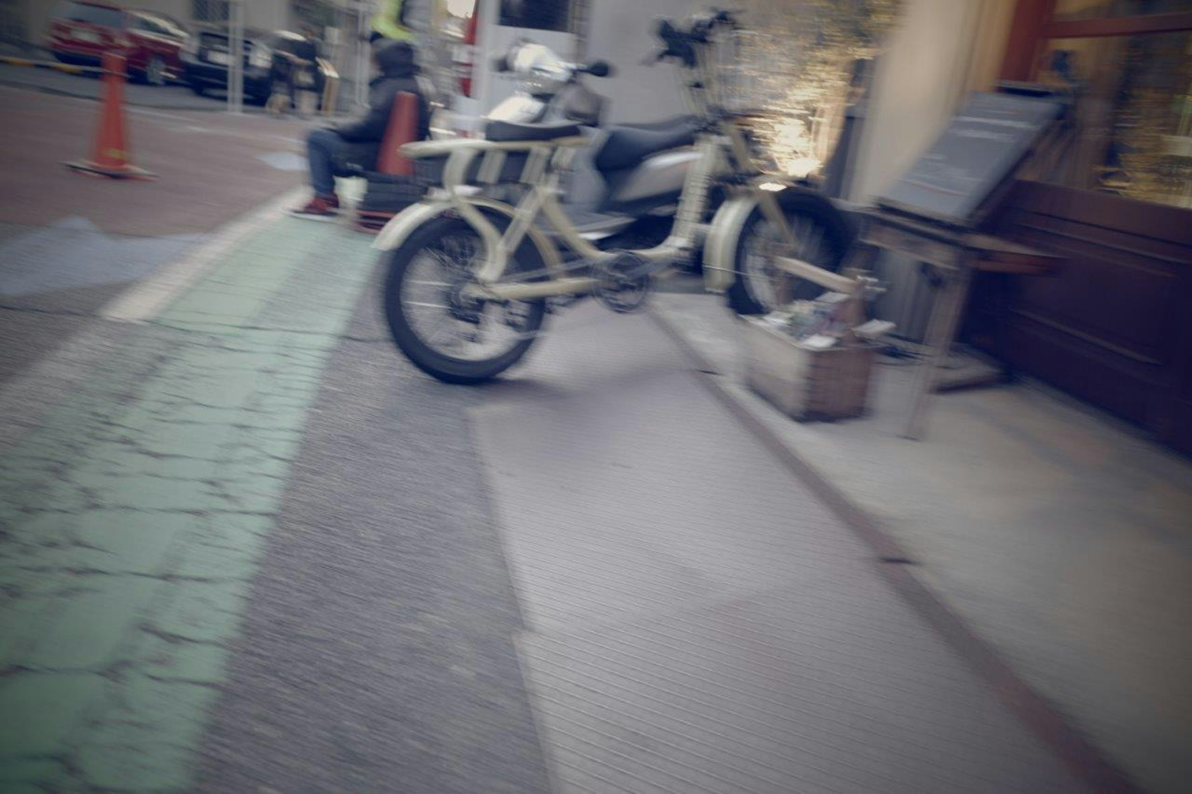 Street scene featuring a white motorcycle and a person sitting on the sidewalk