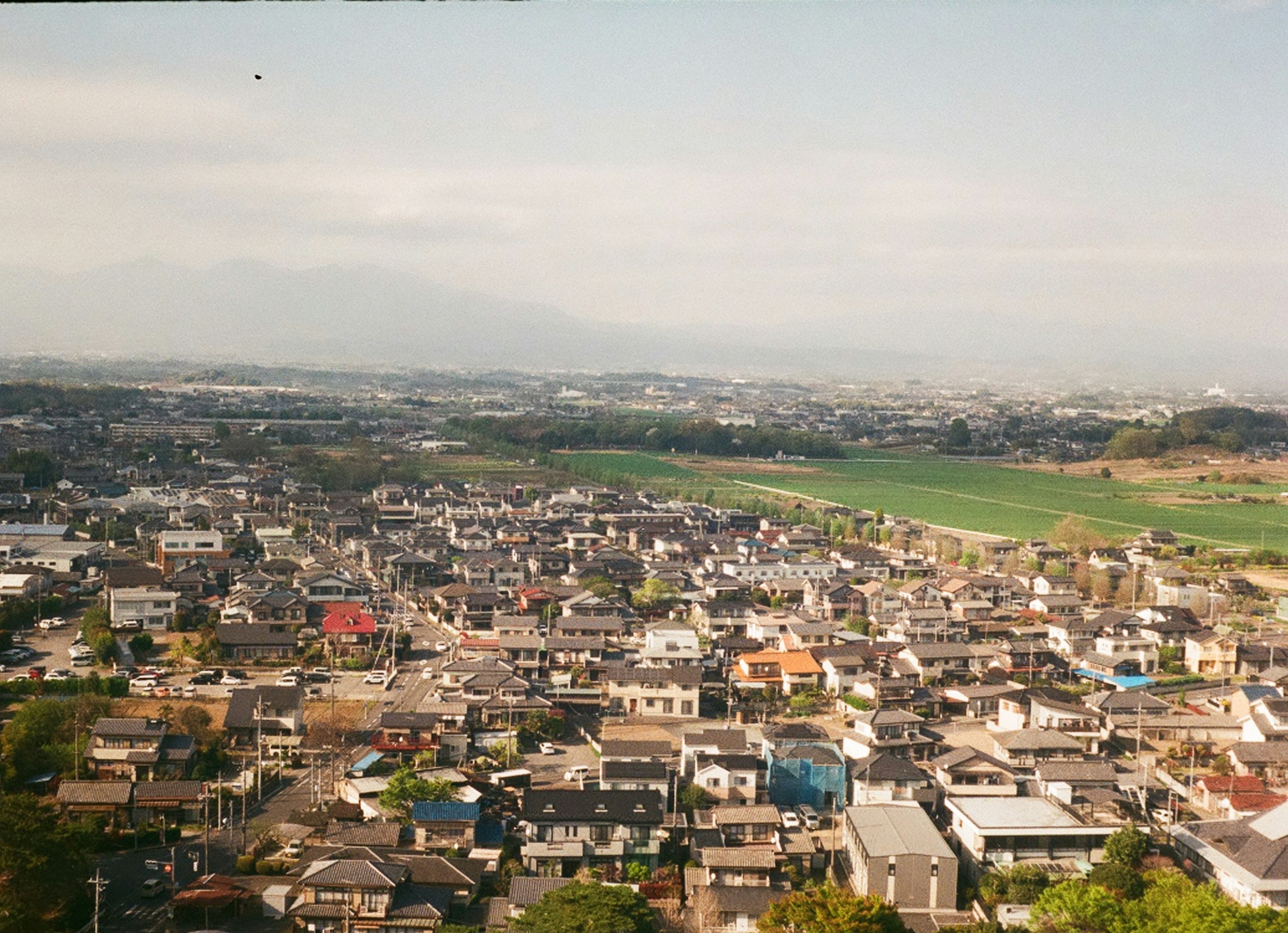 Aerial view of a residential area with houses and green fields