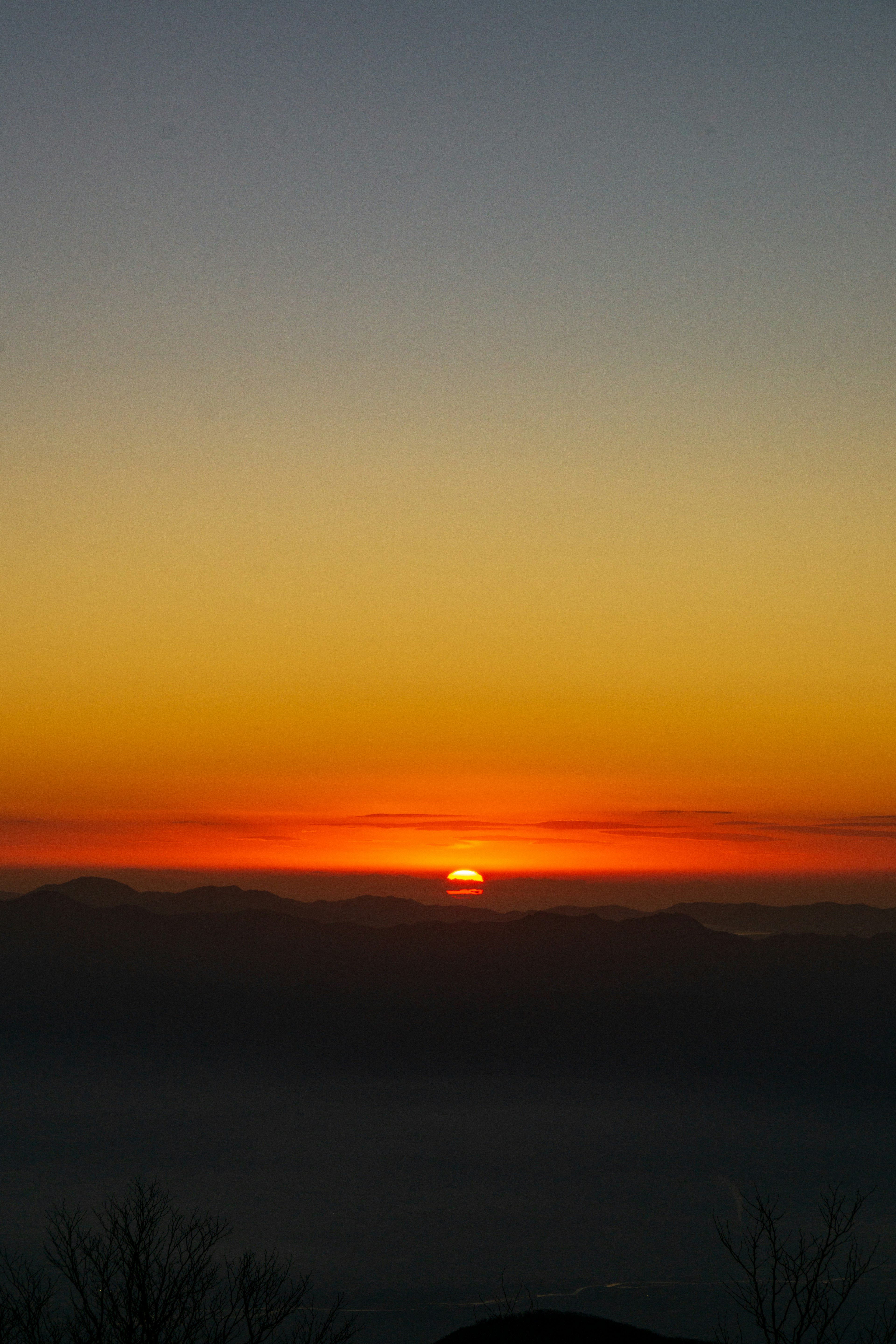 Schöne Sonnenuntergangslandschaft mit orange-gelbem Farbverlauf, der den Himmel erleuchtet