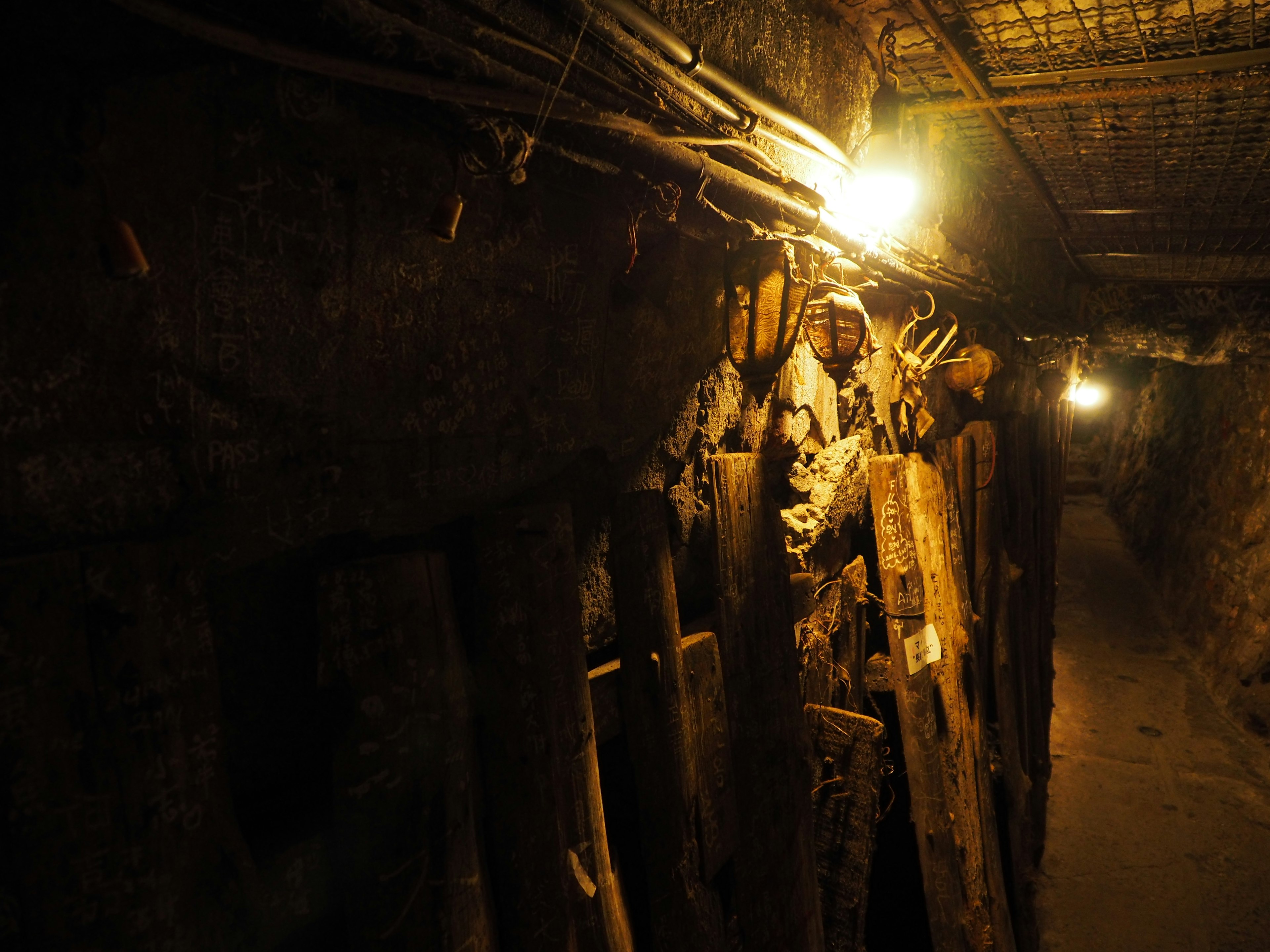 Wooden structures in a dimly lit tunnel with overhead lights