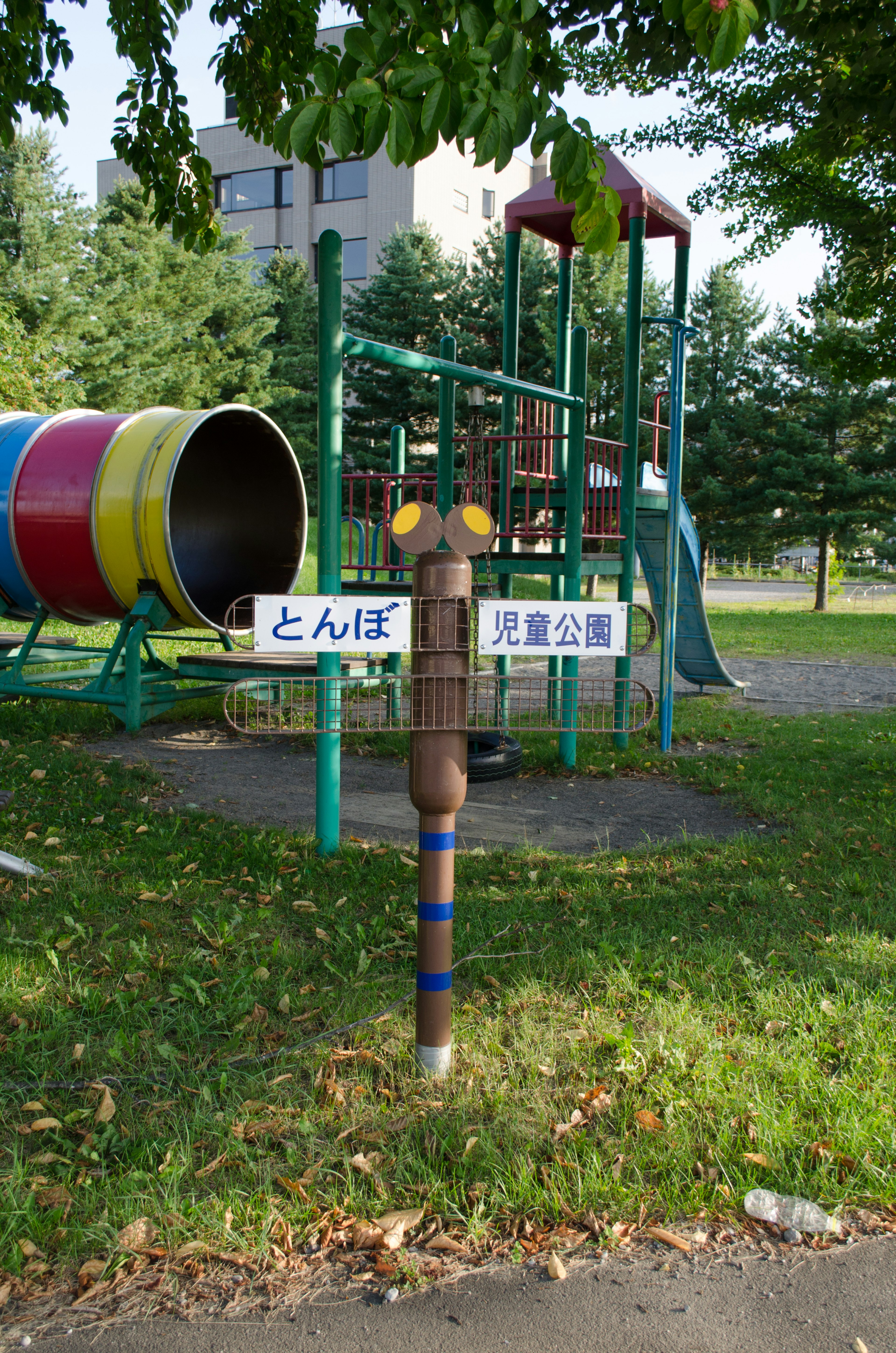 Playground scene featuring a slide and tunnel with signs