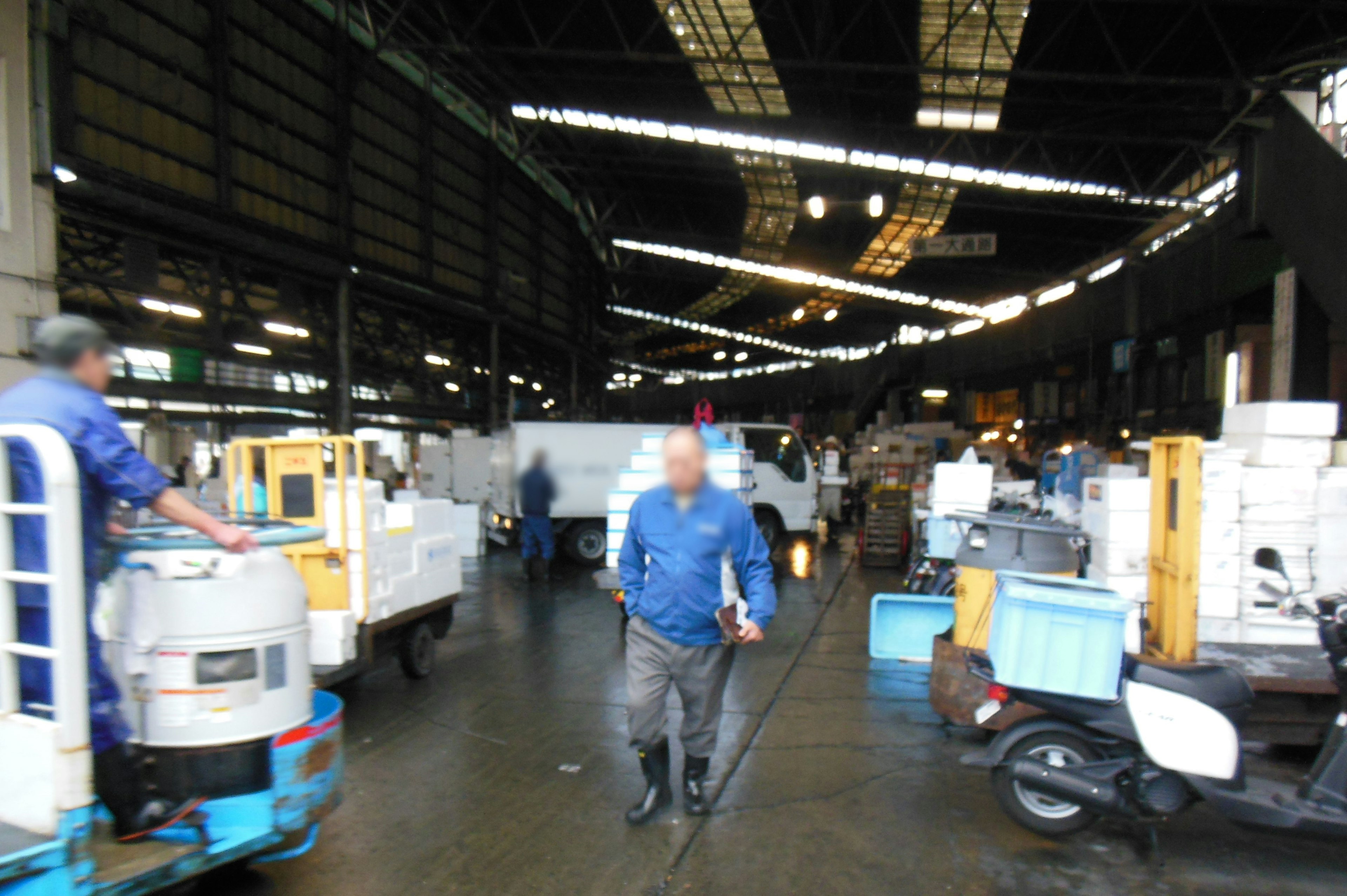 Escena de trabajadores y vehículos de transporte dentro de una fábrica