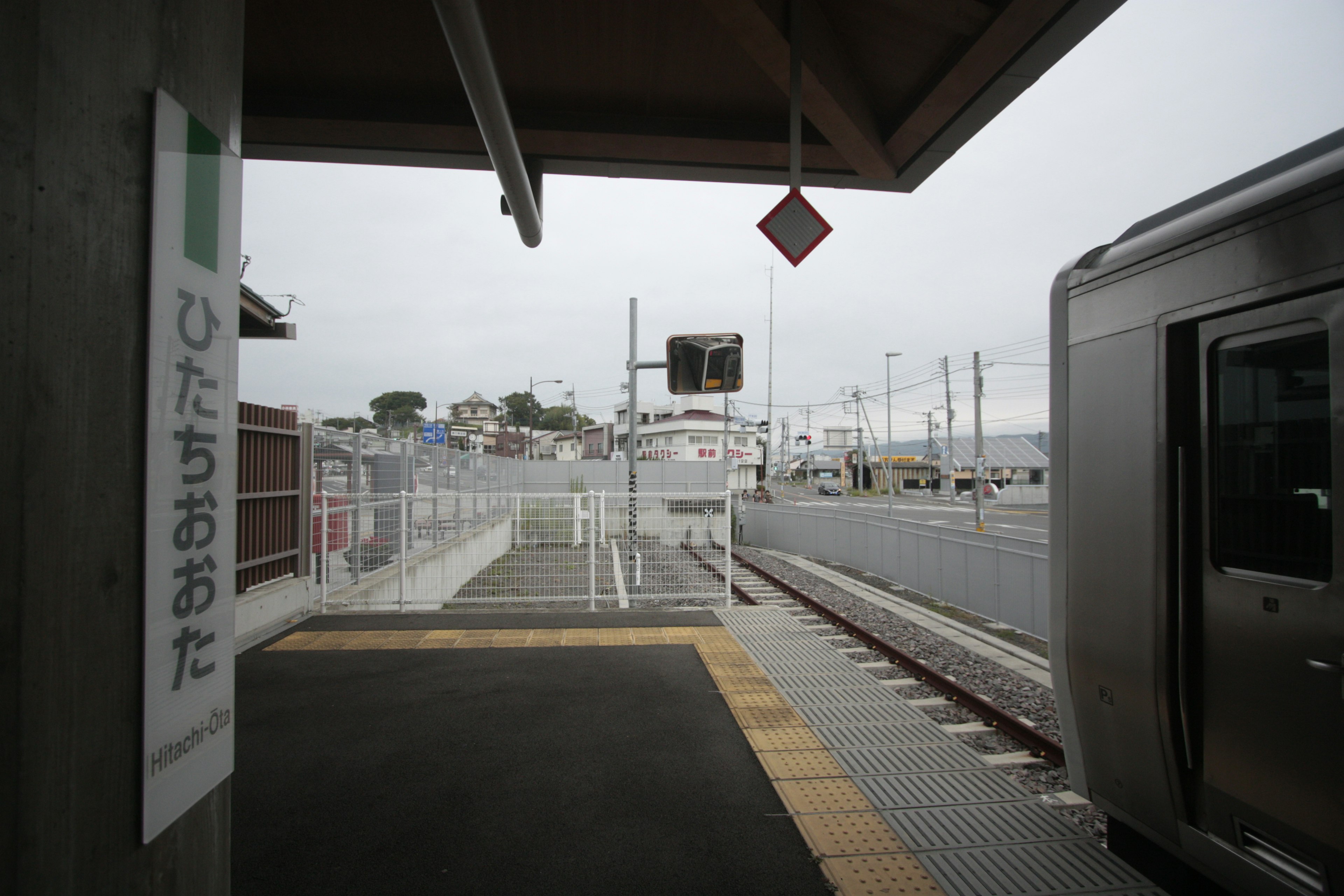 Vista de la plataforma de la estación Hitachi-Oota mostrando el tren y la señalización