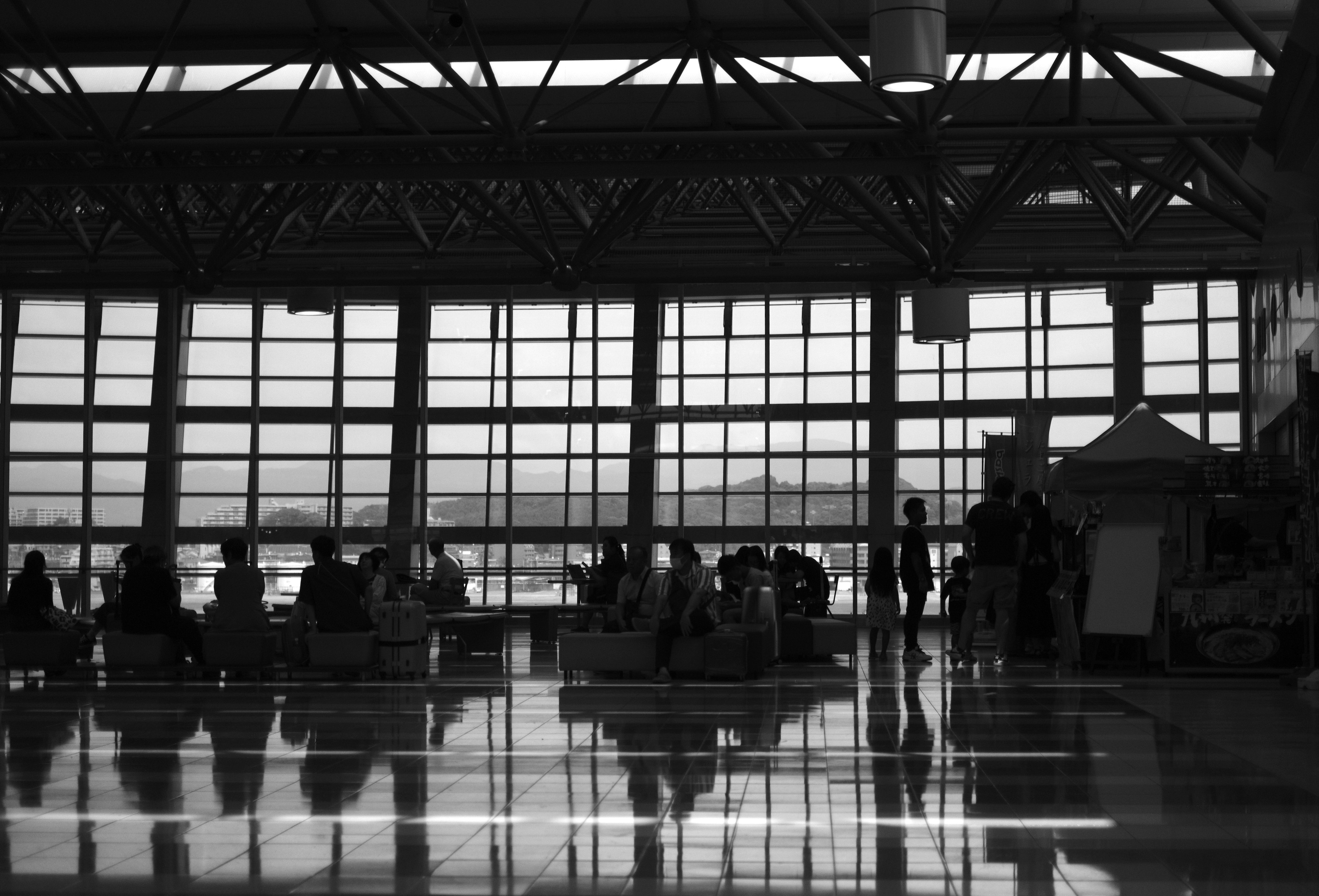 Silhouette eines Wartebereichs im Flughafen mit großen Fenstern