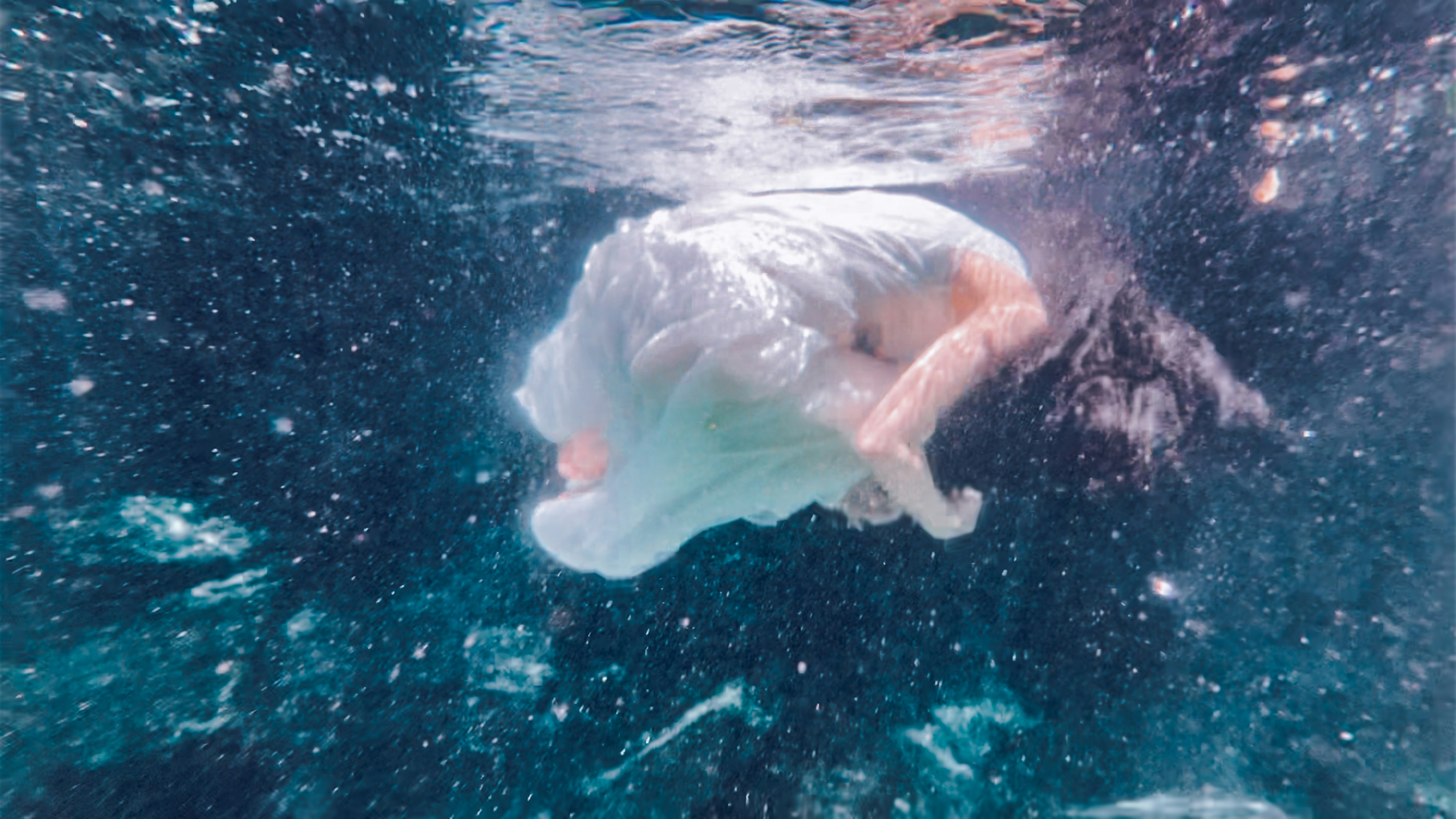 Una donna in un abito bianco fluente immersa nell'acqua