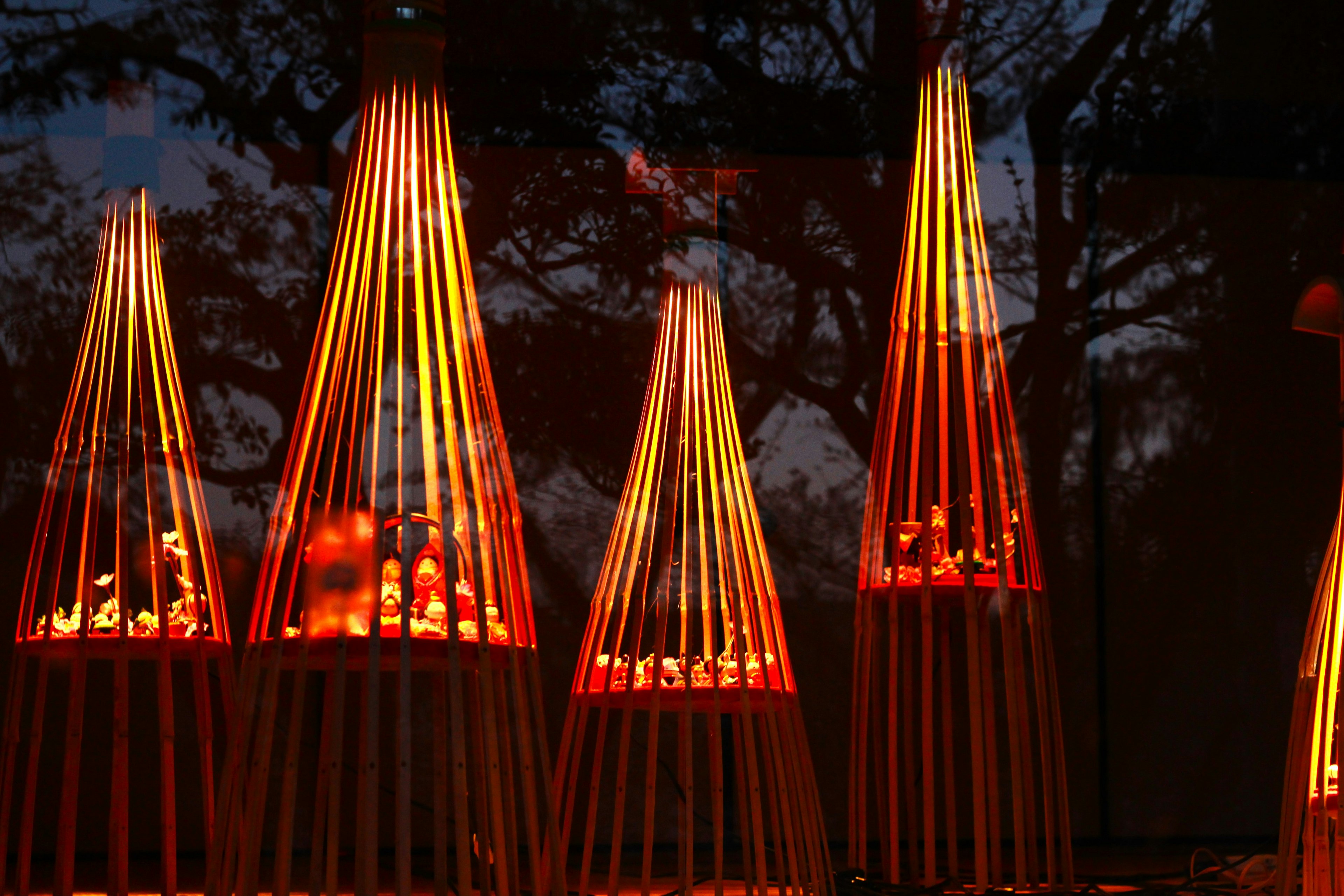 Objets en bois décoratifs illuminés par une lumière rouge disposés en rangée