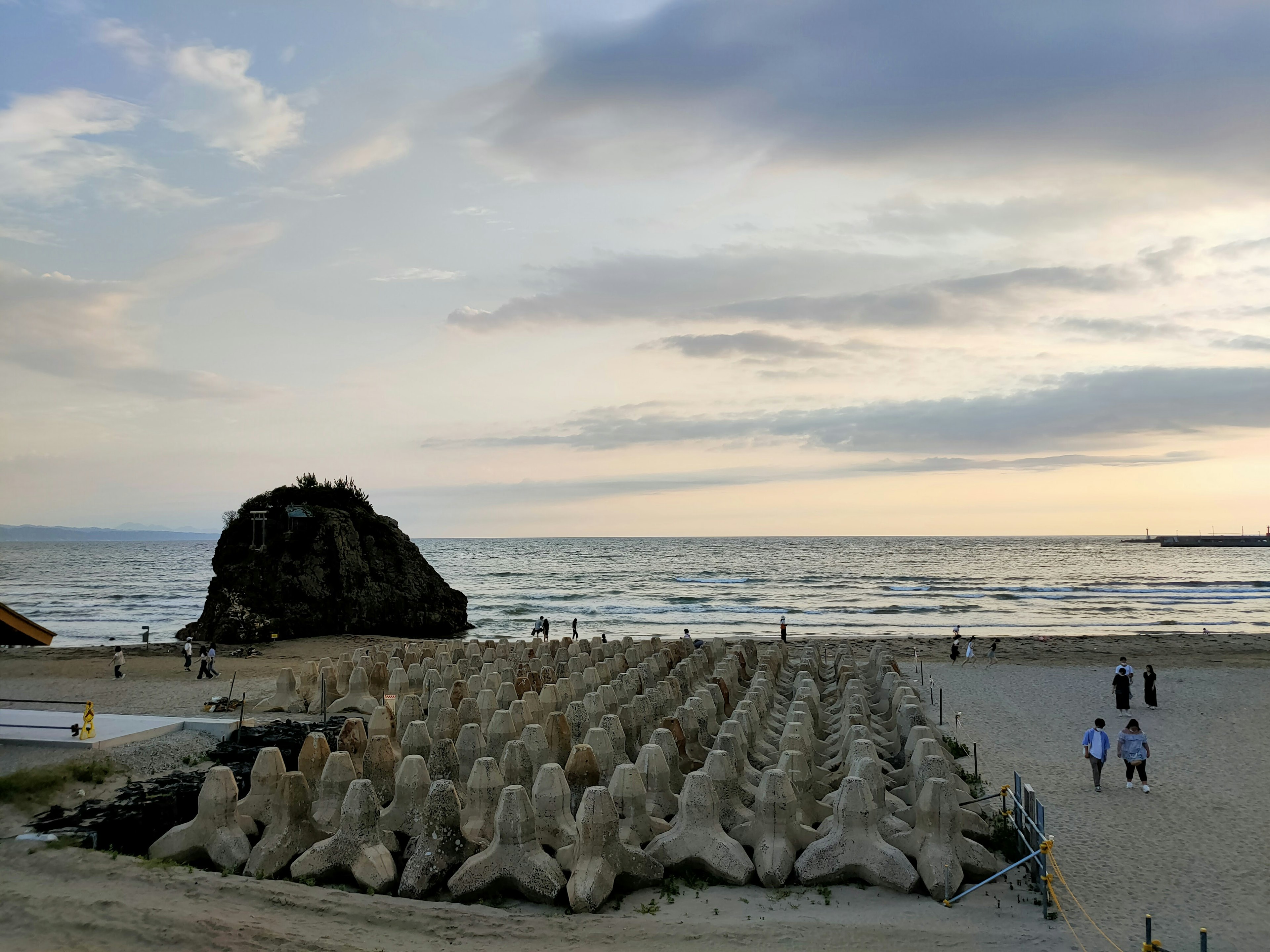 Scène de plage avec des sculptures de sable et une formation rocheuse