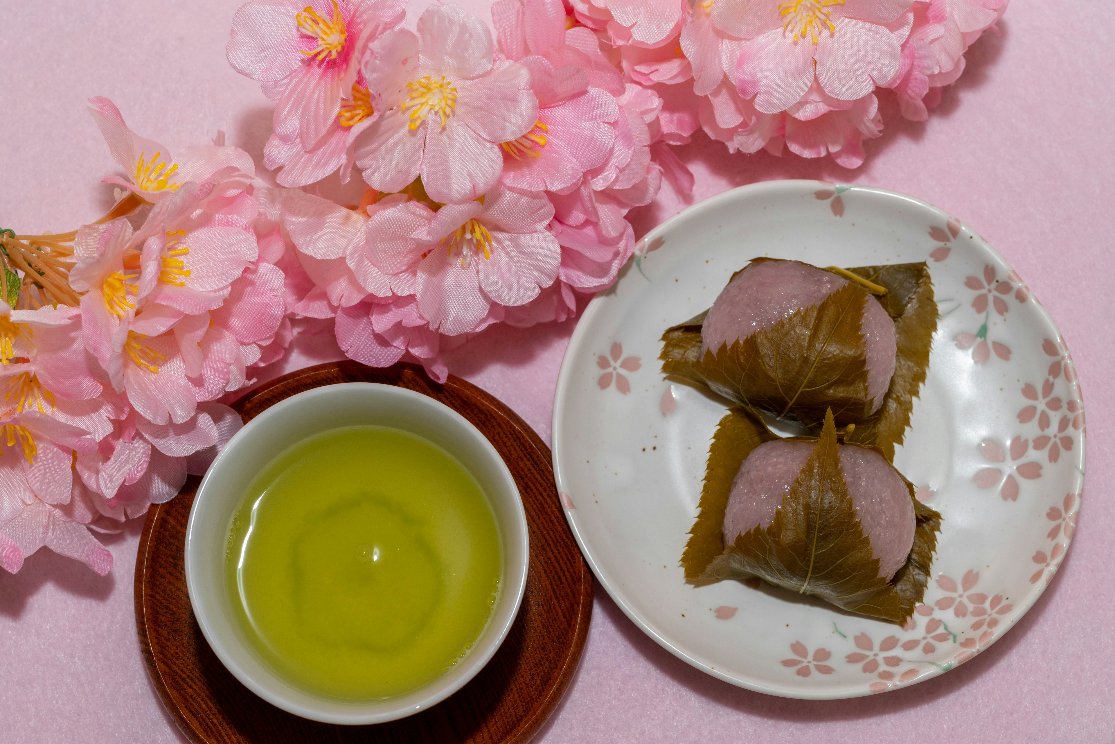 Hermosa presentación de dulces japoneses con flores de cerezo y té