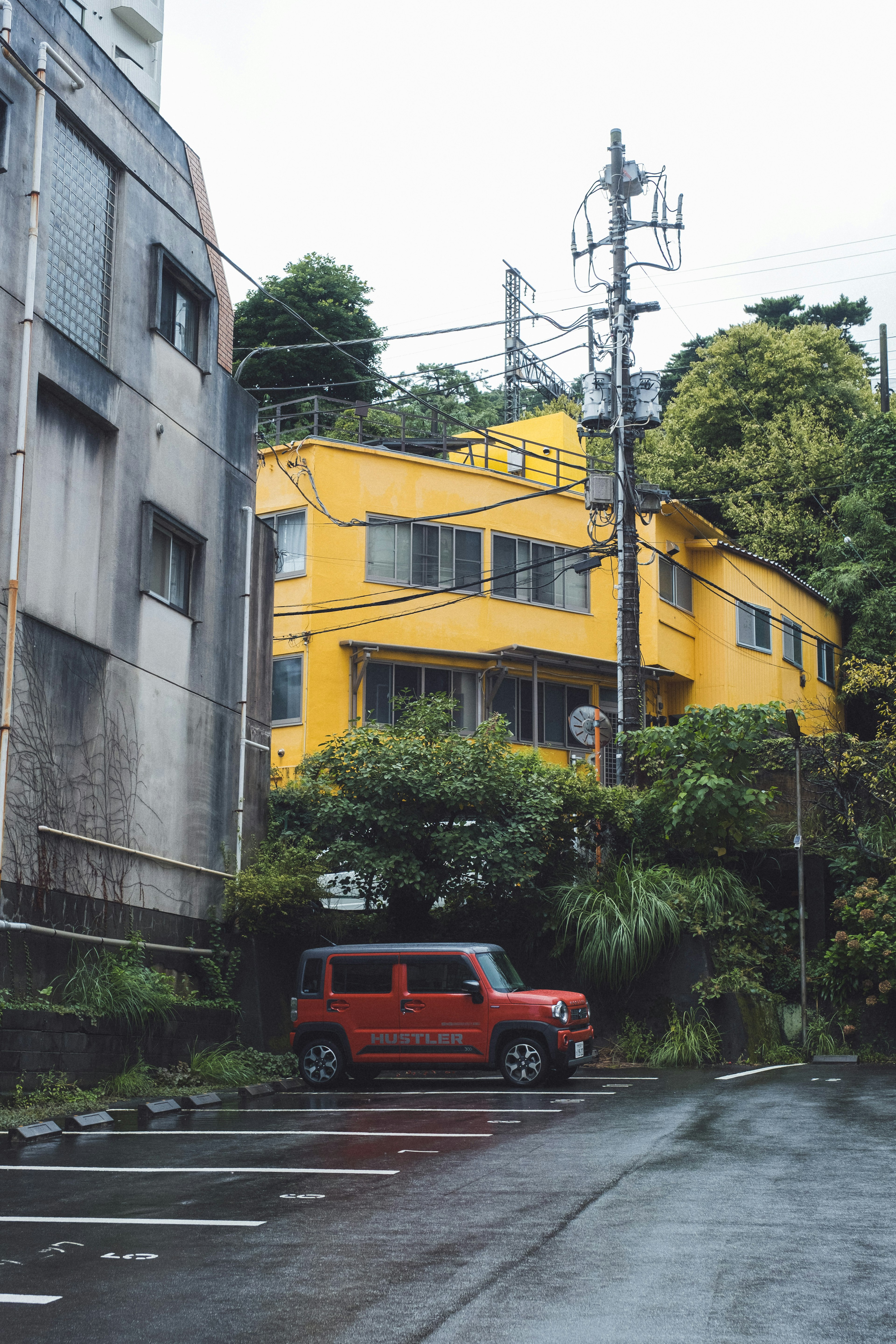 Paysage avec une voiture rouge et une maison jaune