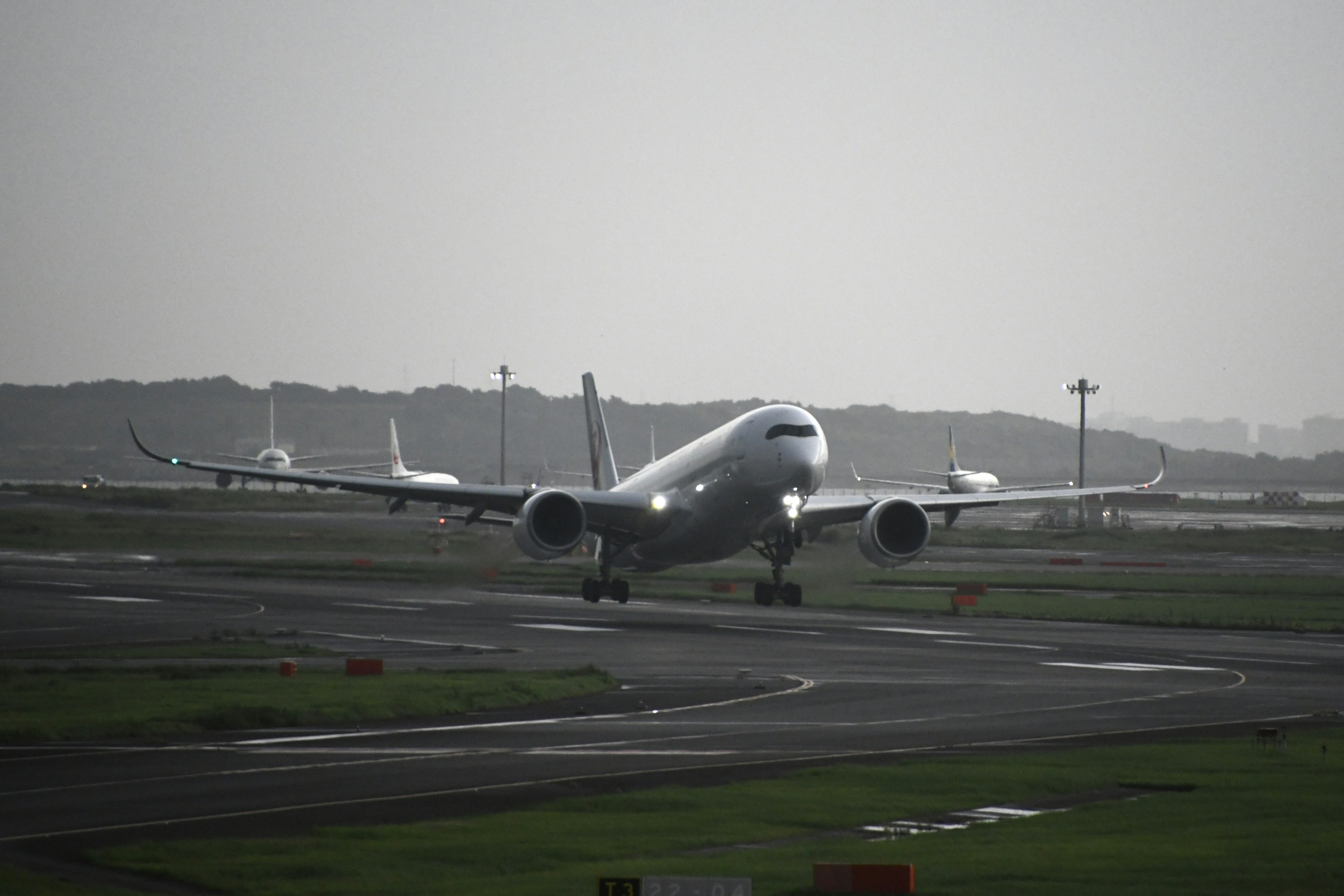 Airplane taxiing on the runway with a hazy background sky