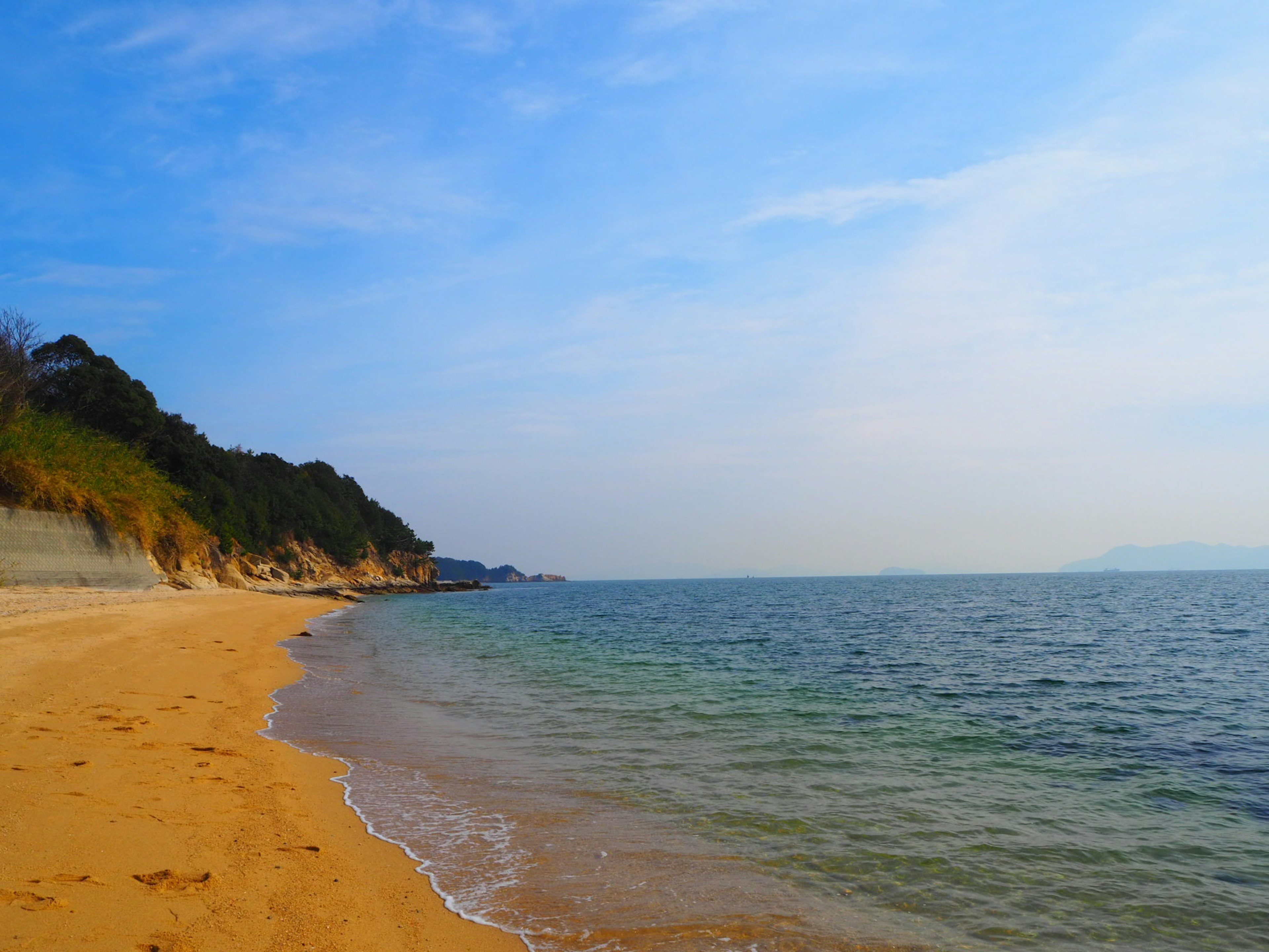 Pemandangan pantai yang indah dengan langit biru dan gelombang lembut