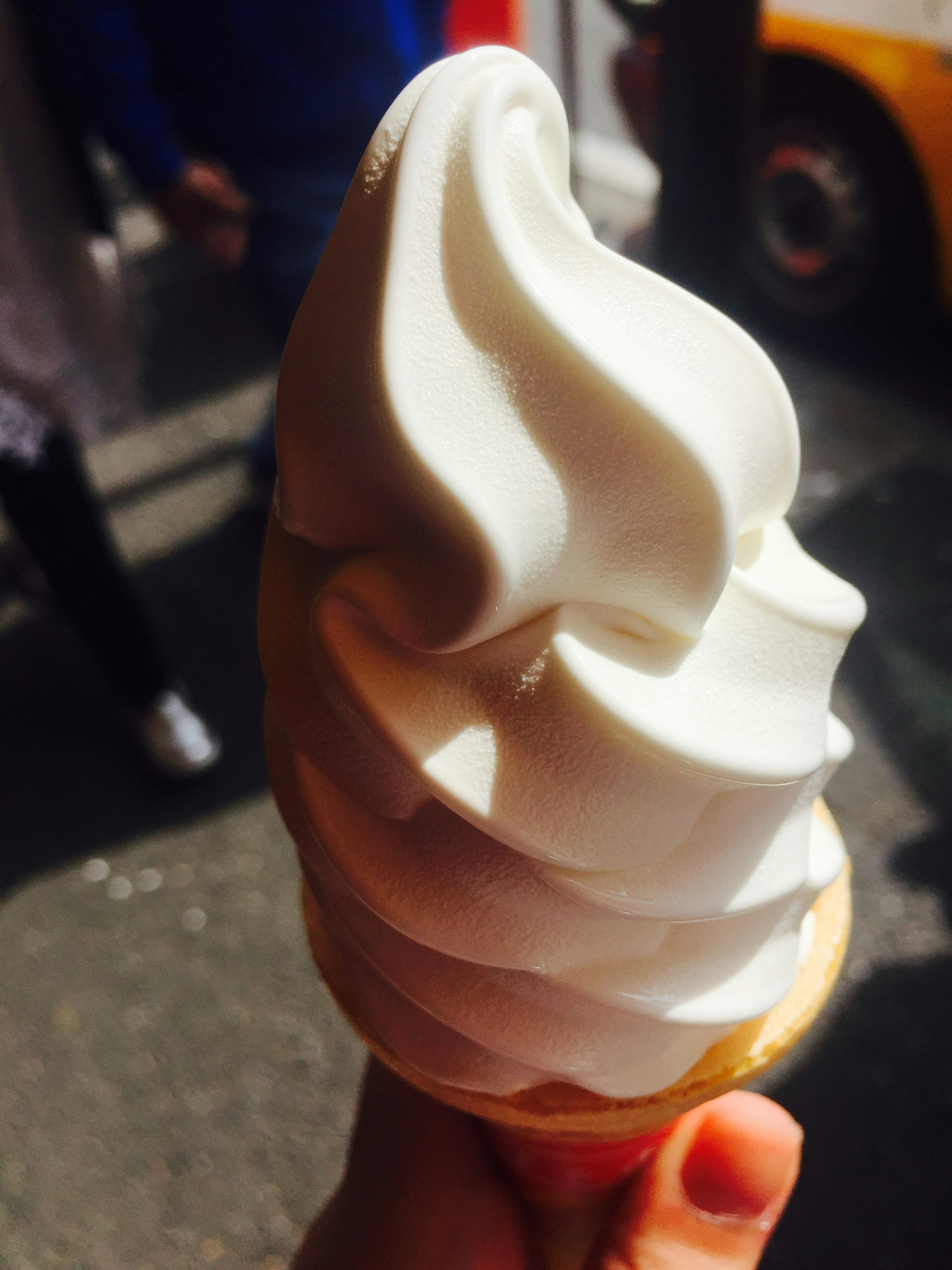 A swirl of white soft serve ice cream in a cone