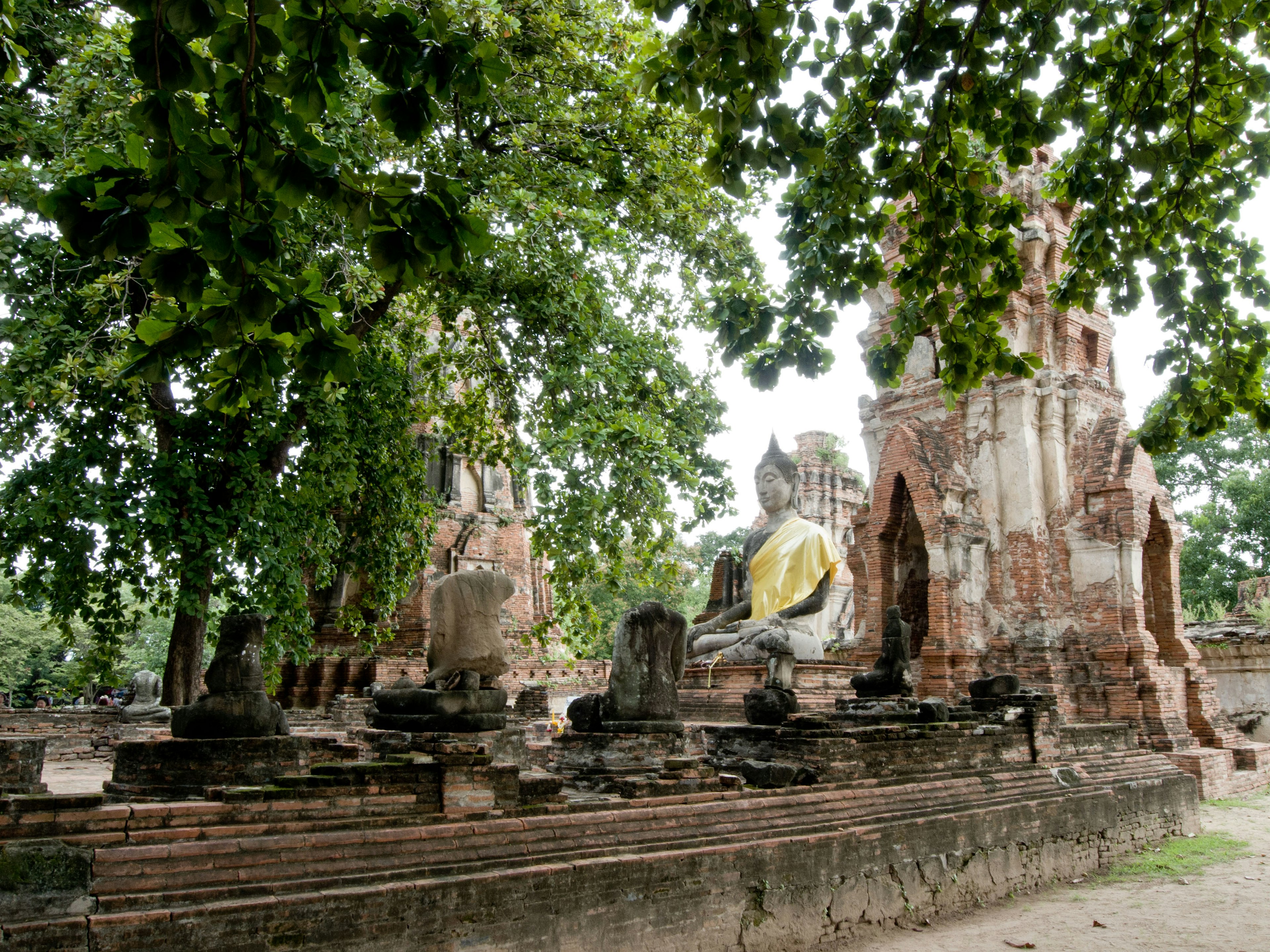 Ruines d'un ancien temple avec une grande statue de Bouddha dans un paysage serein