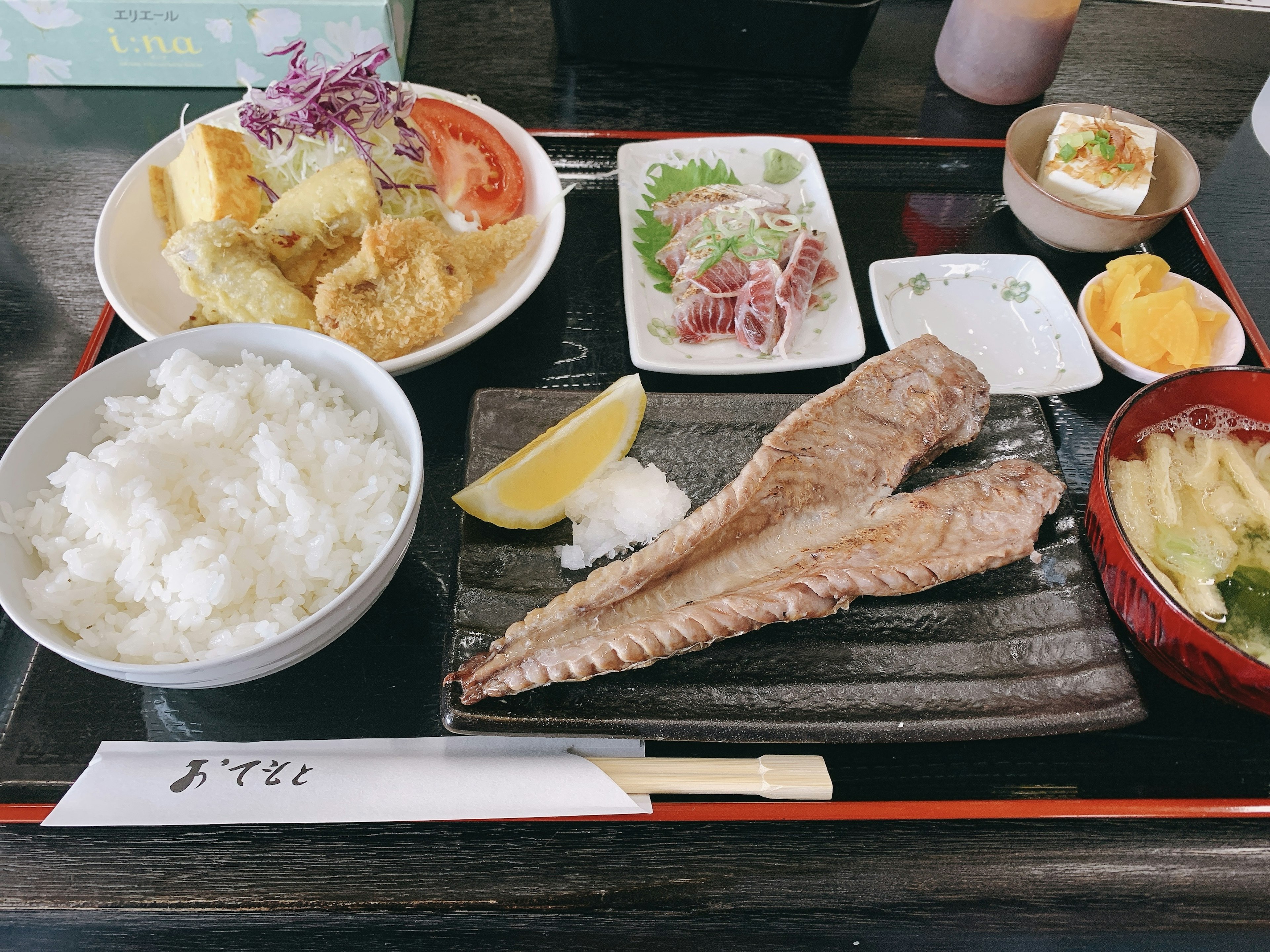 和食の定食プレートにはご飯、魚、天ぷら、刺身、味噌汁が含まれている