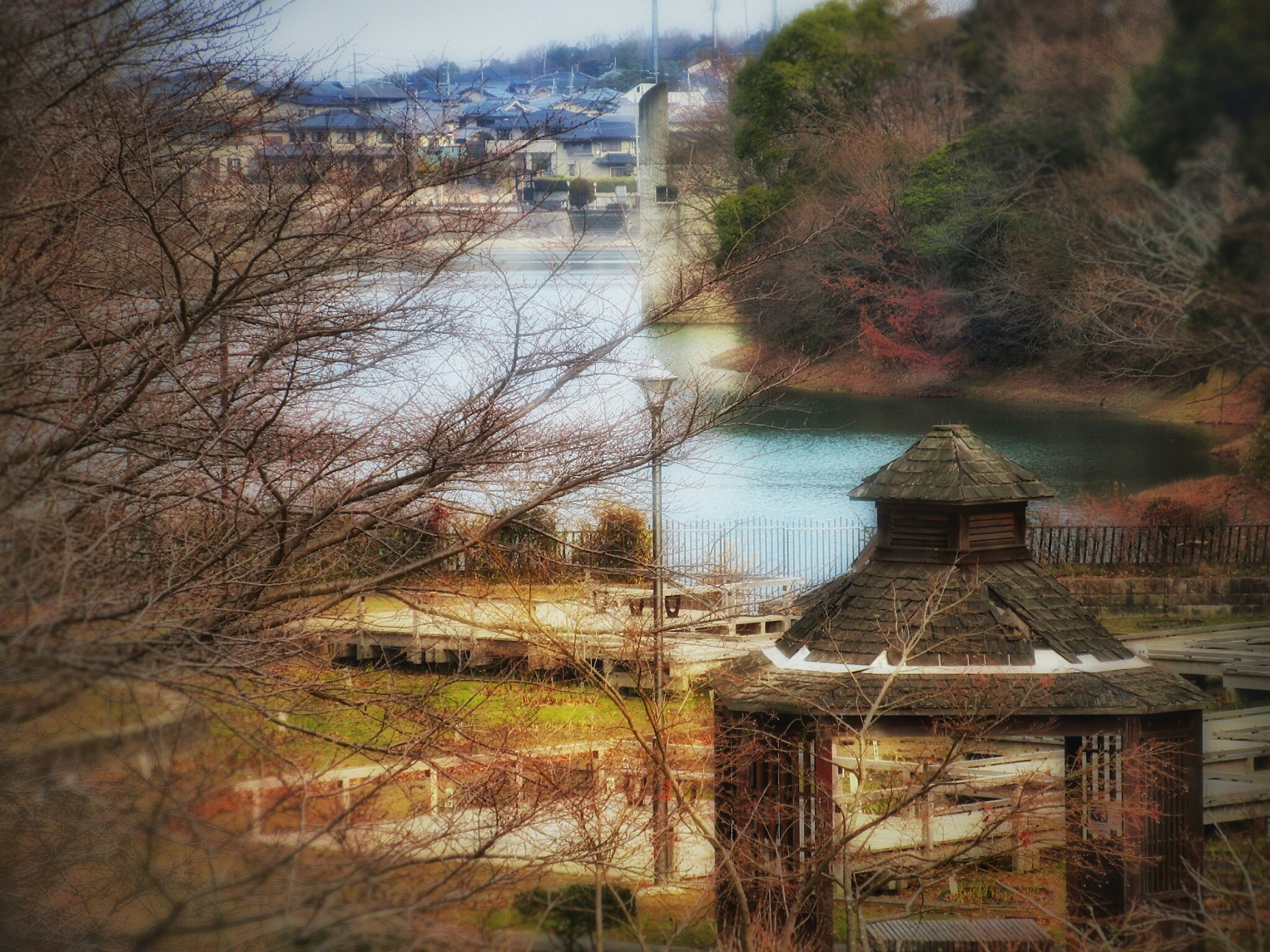 Blick auf einen Park mit einem Pavillon und einem Fluss, umgeben von Bäumen