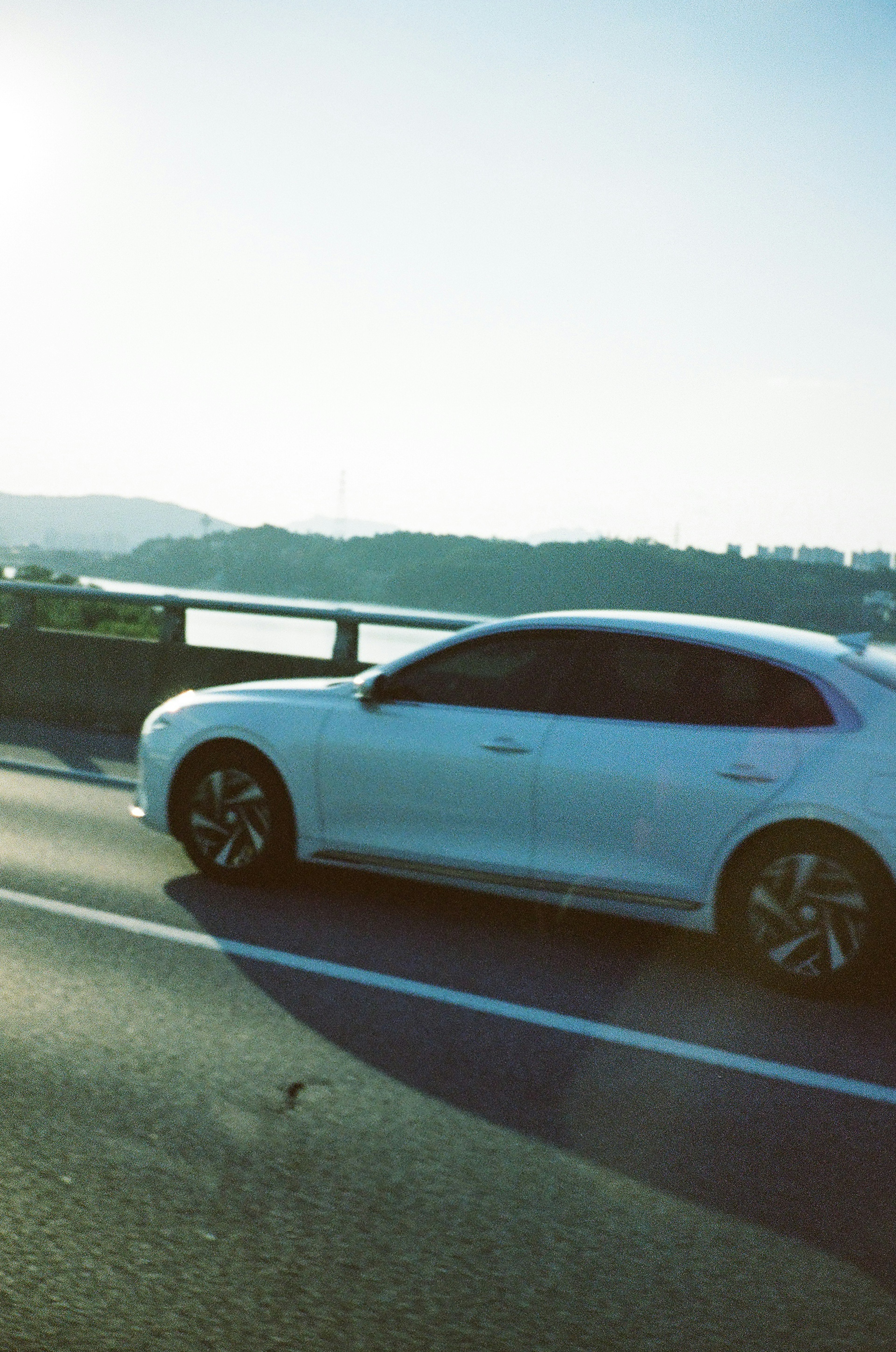 Un coche blanco conduciendo por una carretera junto al río