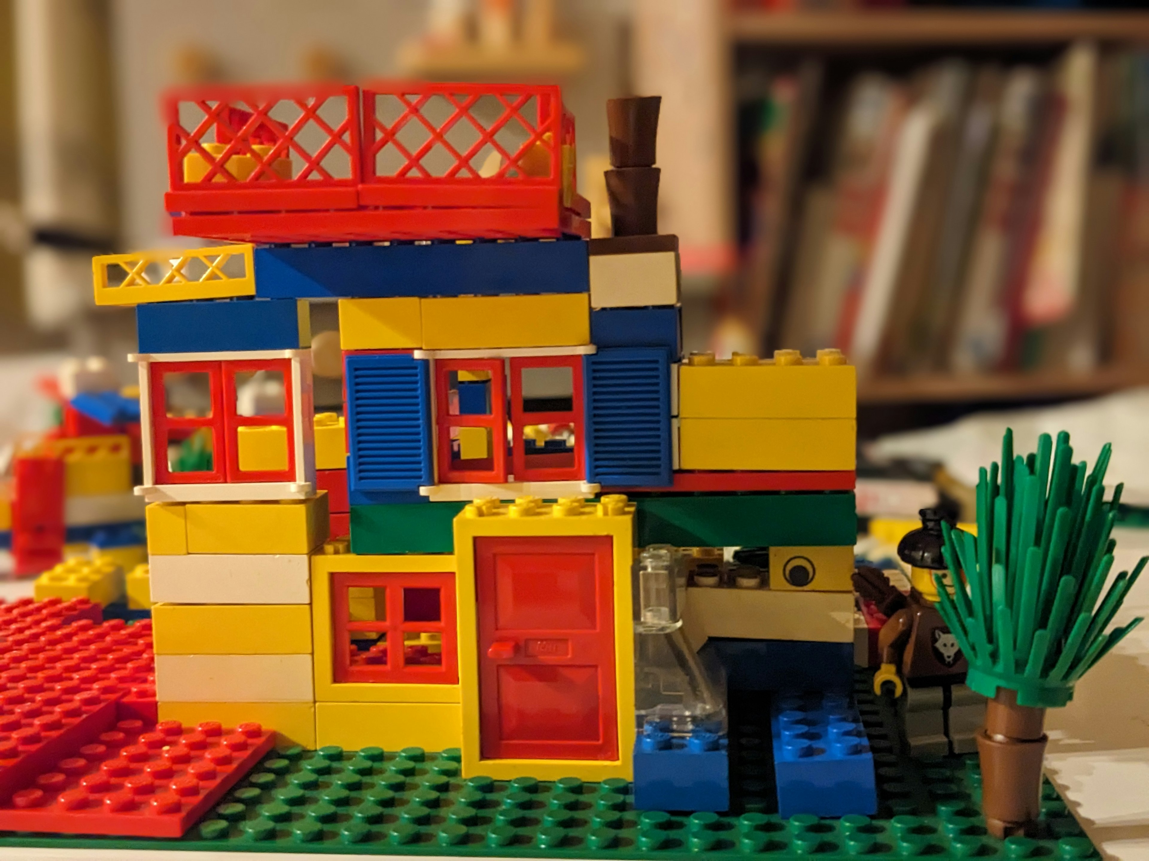 Modèle de maison LEGO coloré avec une porte rouge et une plante verte