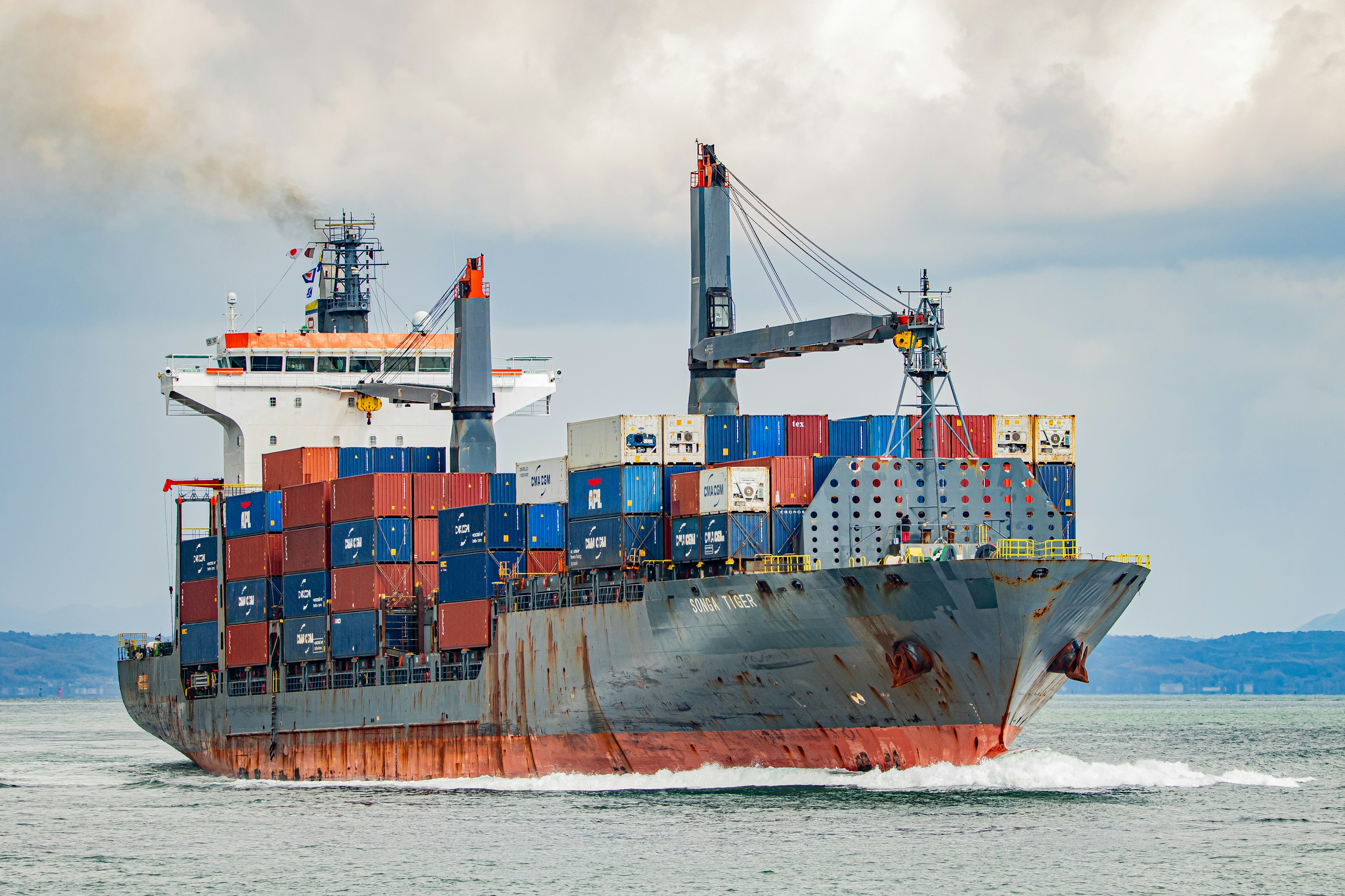 Frachtenschiff, das auf dem Meer mit bunten Containern segelt