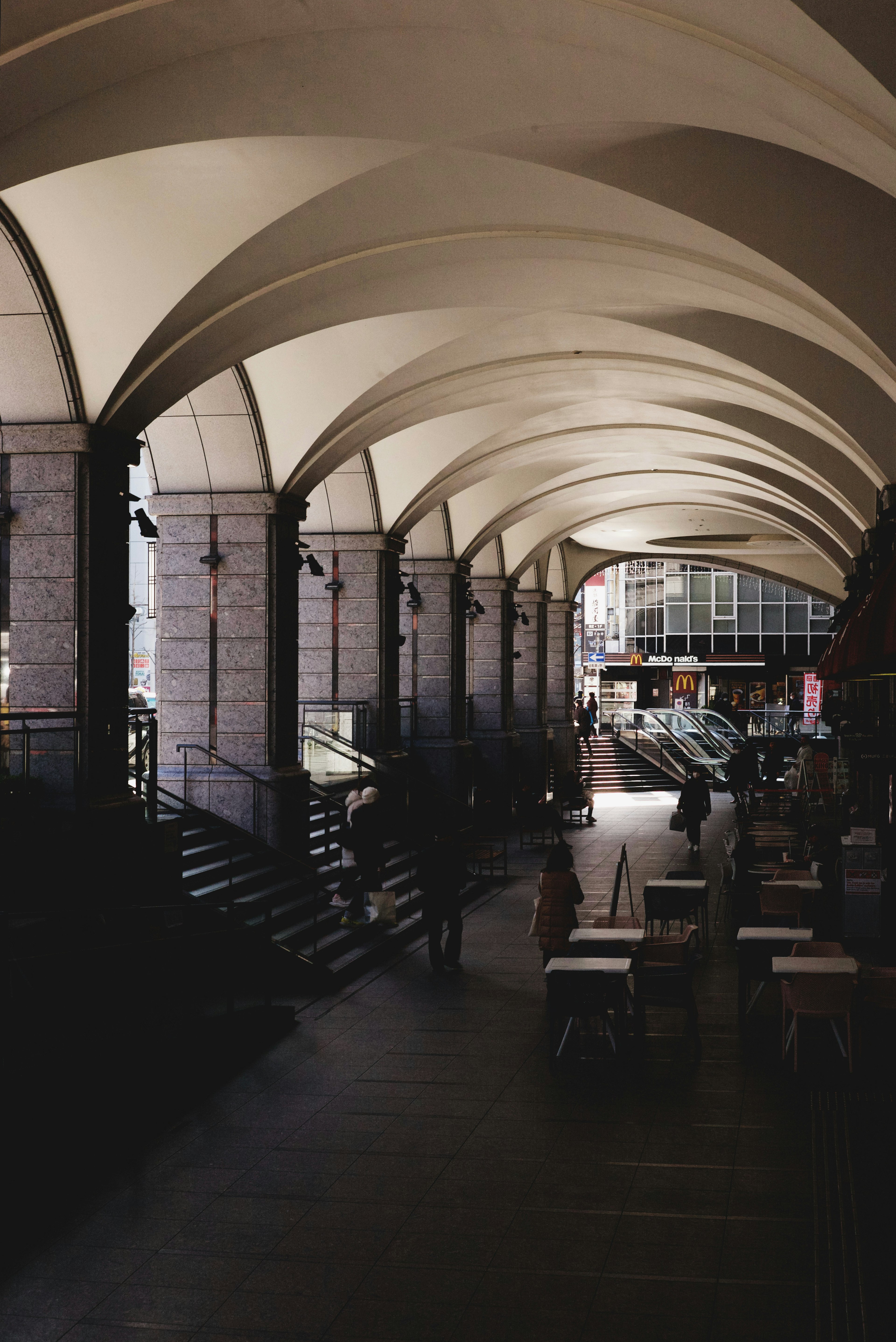 Spacious corridor featuring arched ceilings and stone columns