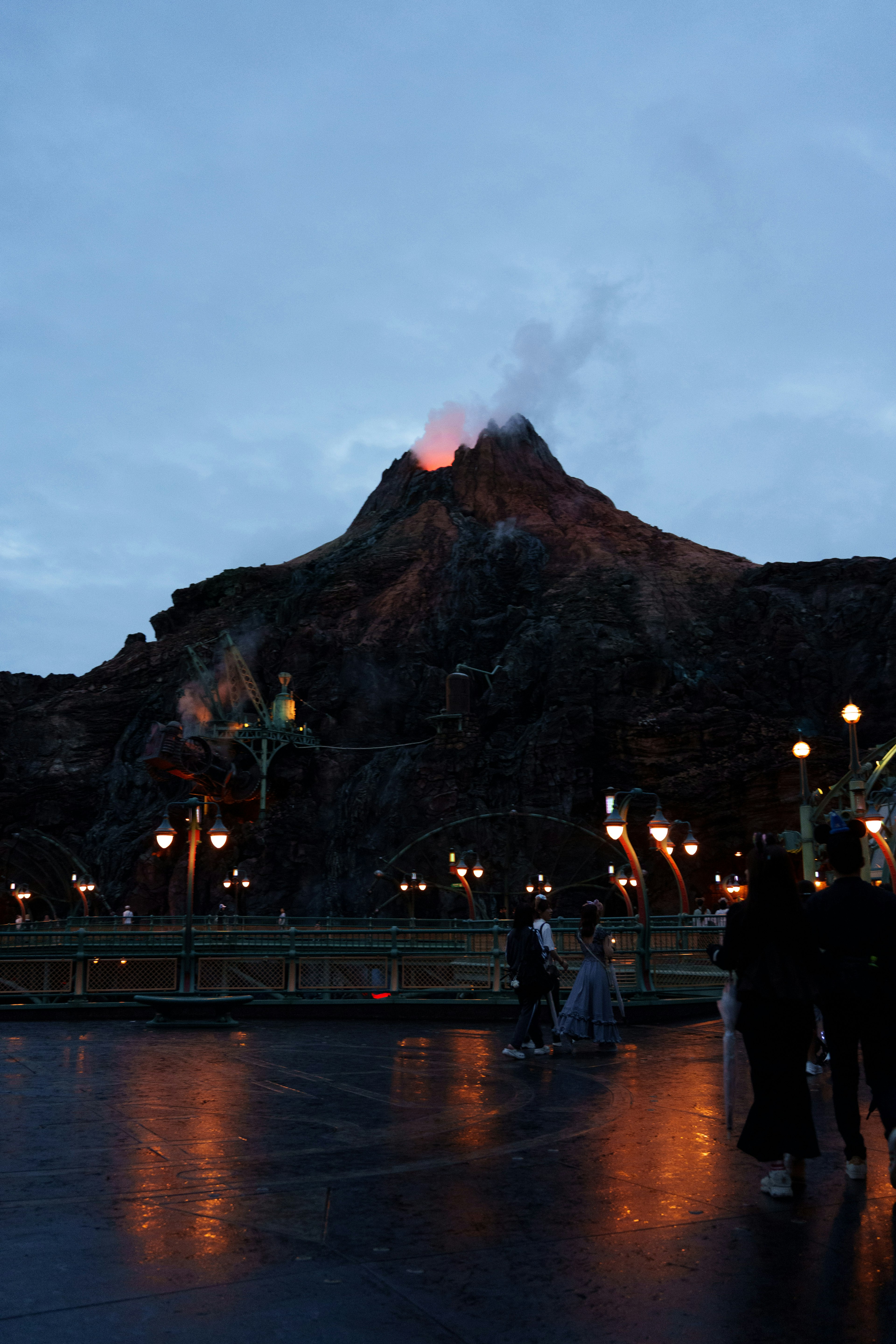 夜間噴發的火山景觀和附近行走的人們