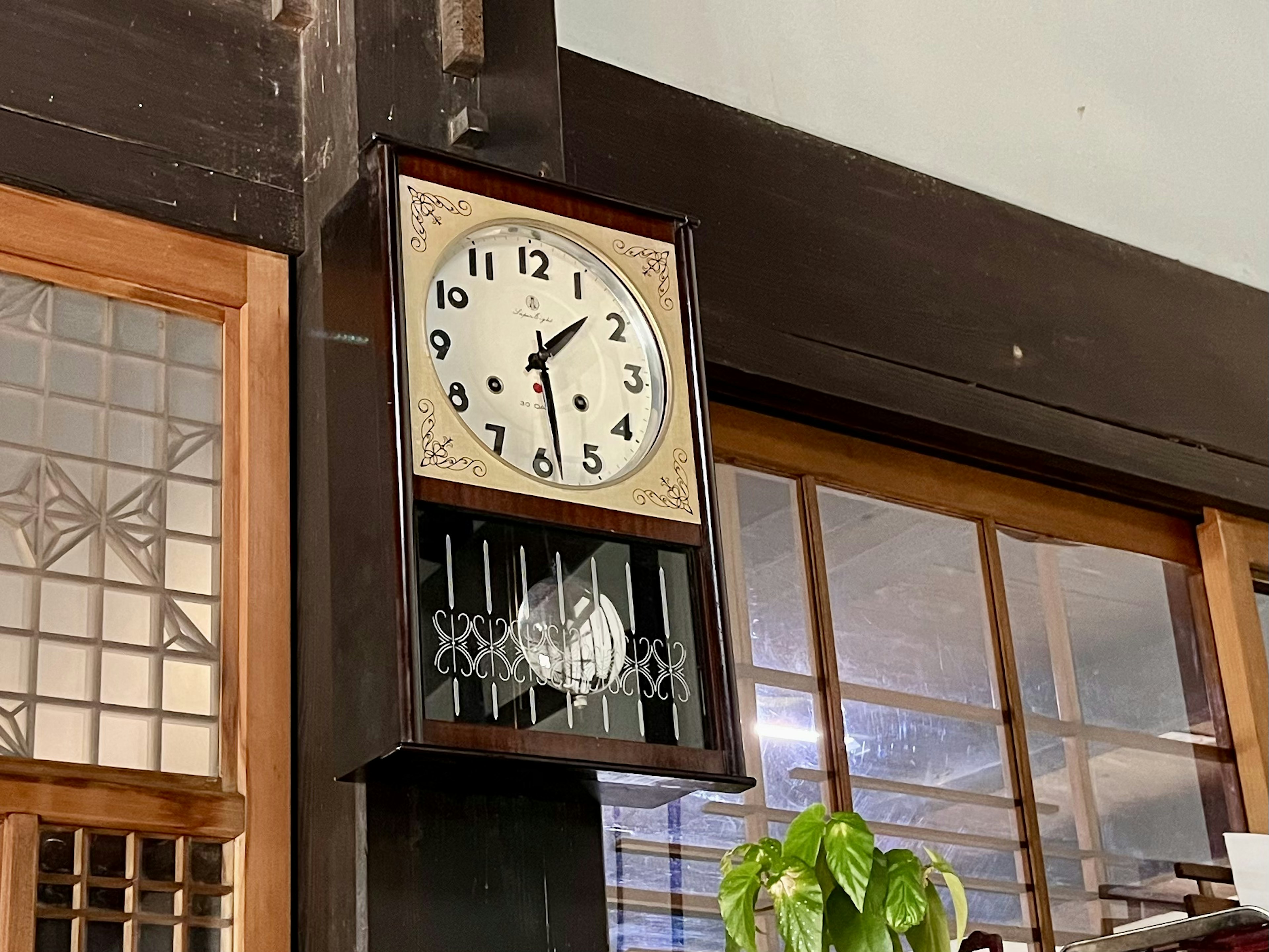 Reloj de pared vintage con marco de madera colgado en una pared de madera