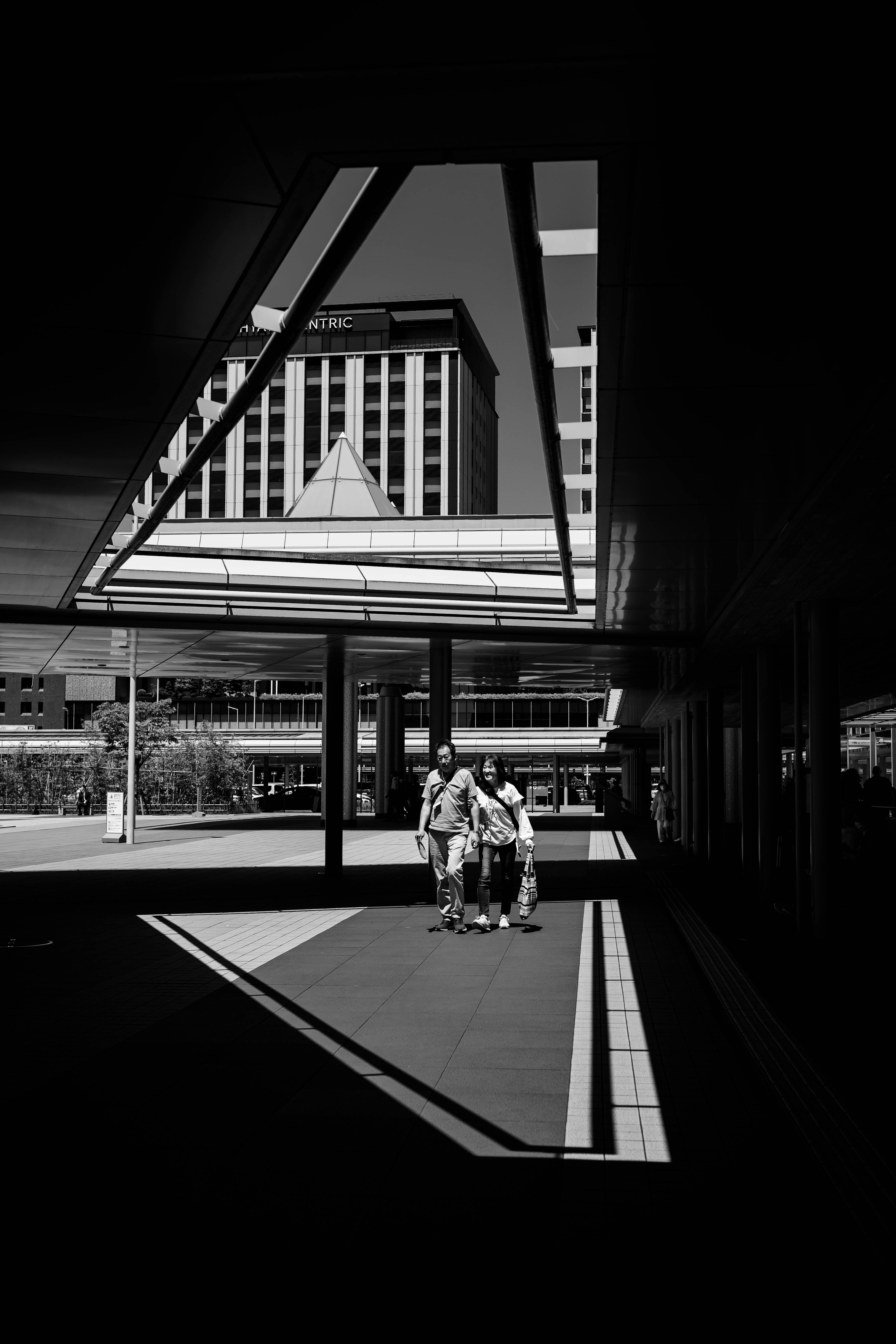 Imagen en blanco y negro de personas caminando a través de una arquitectura moderna