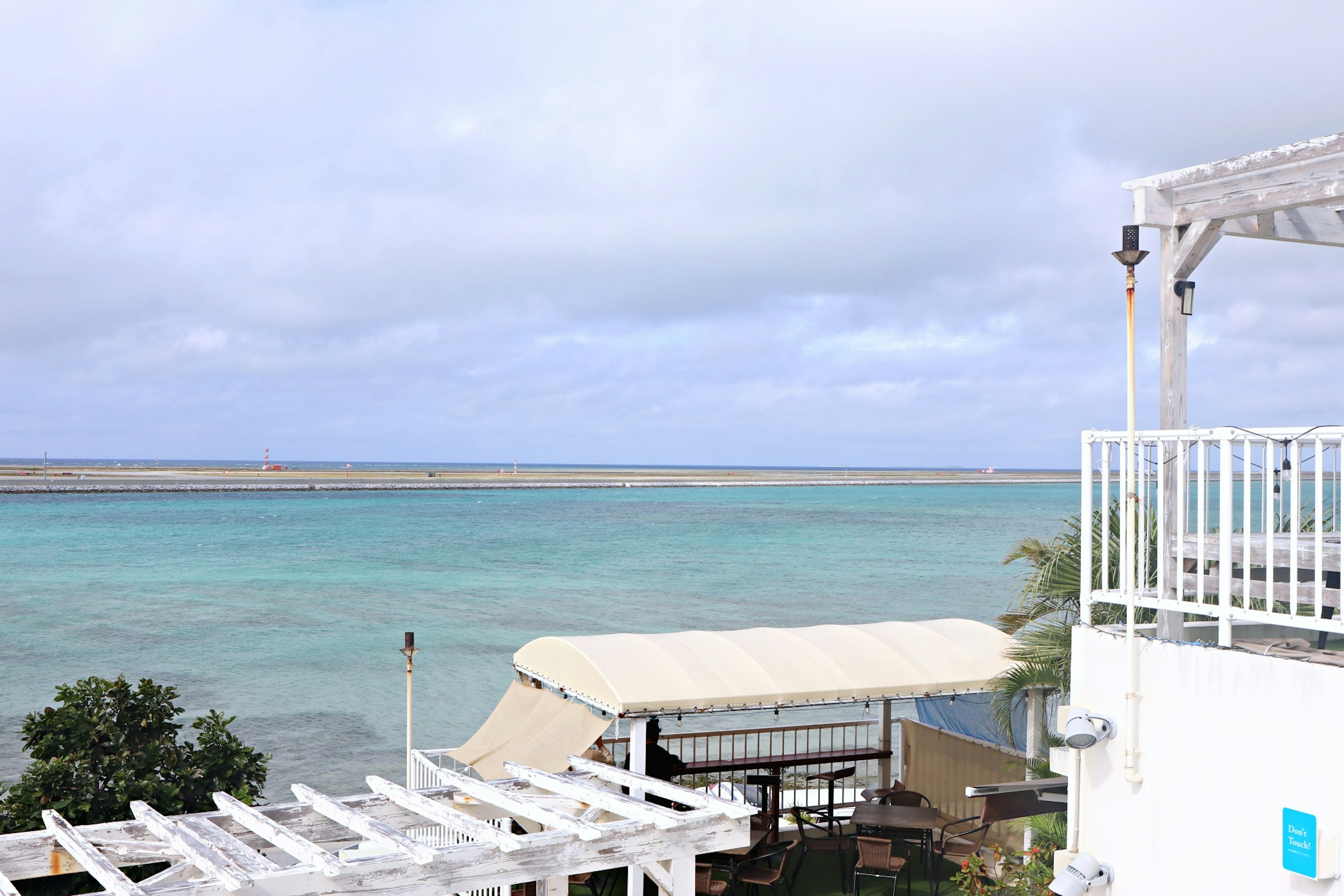 Coastal resort view with turquoise water and cloudy sky