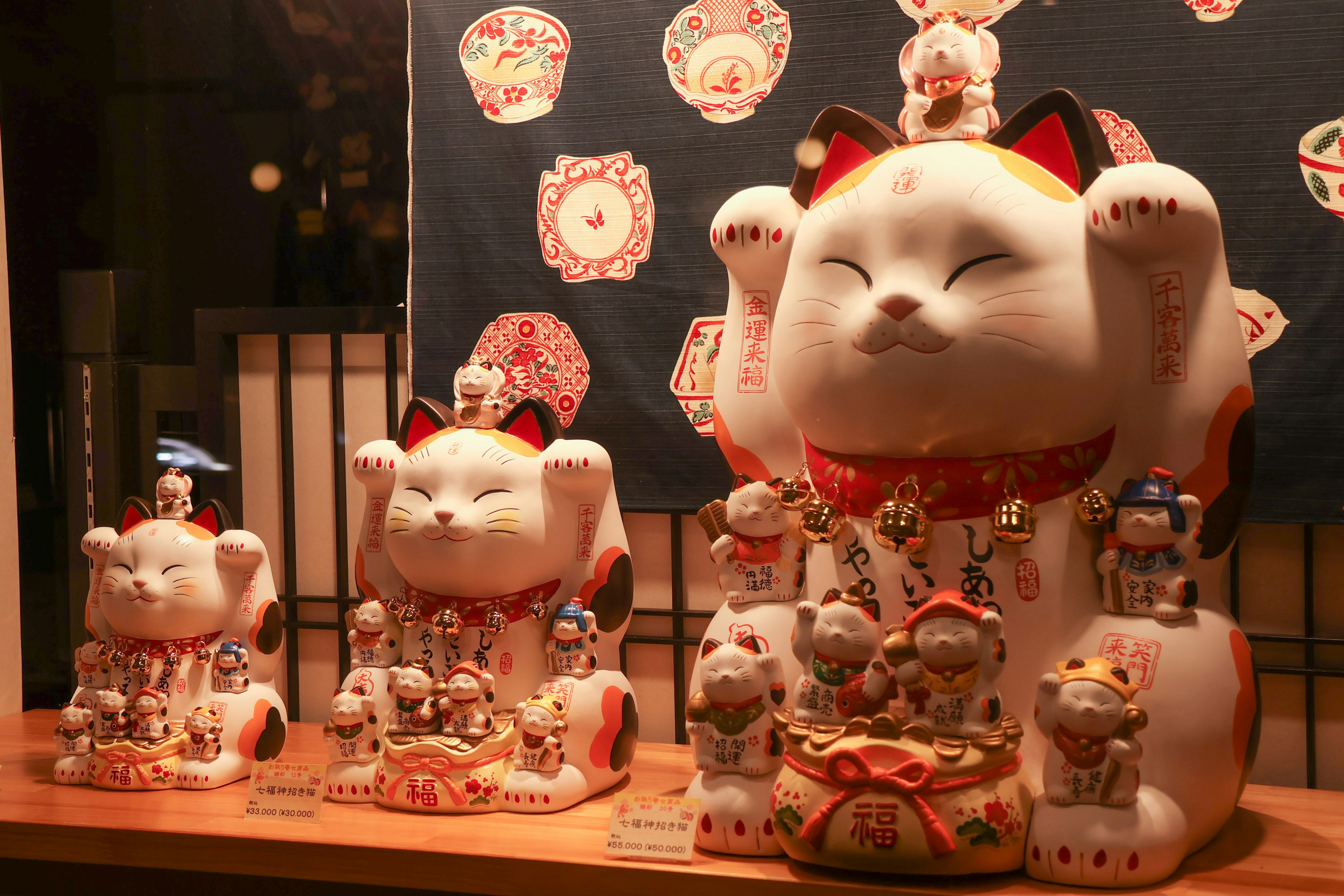 Ausstellung verschiedener Maneki-neko-Figuren in lebendigen Farben