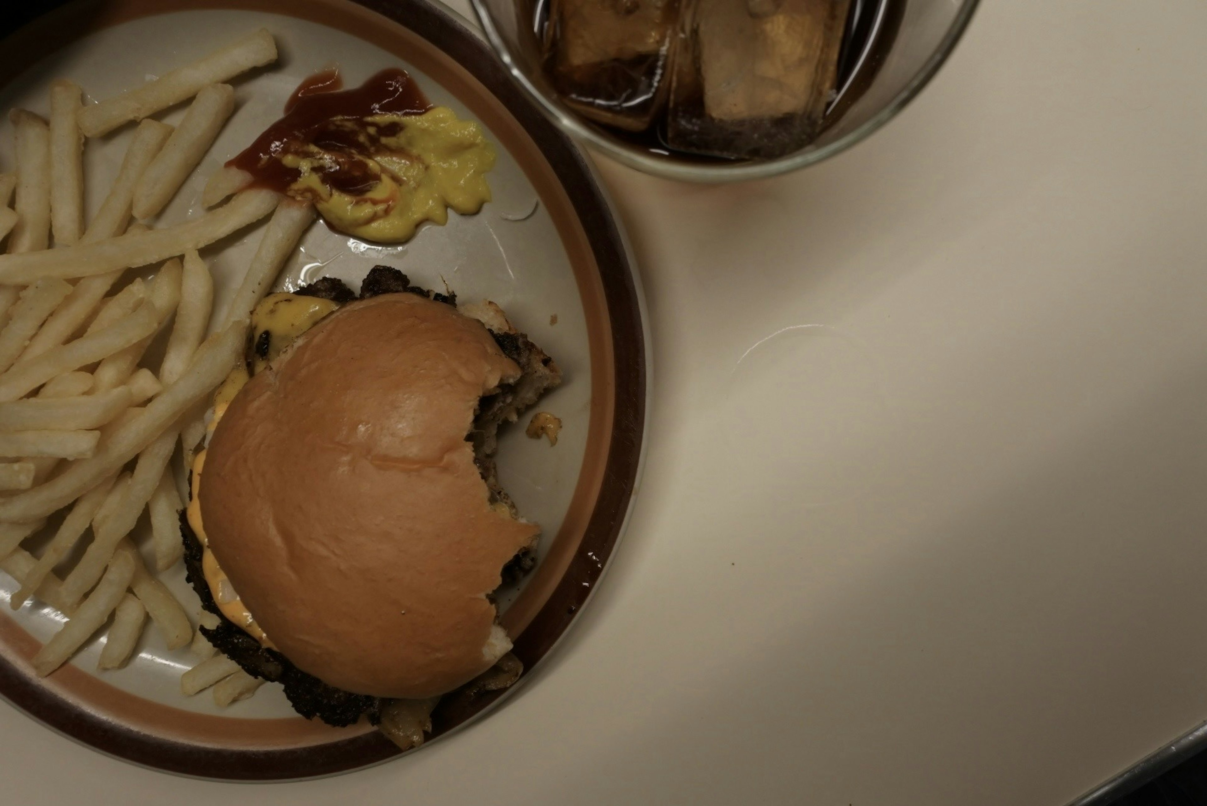 Assiette avec un hamburger, des frites et une boisson