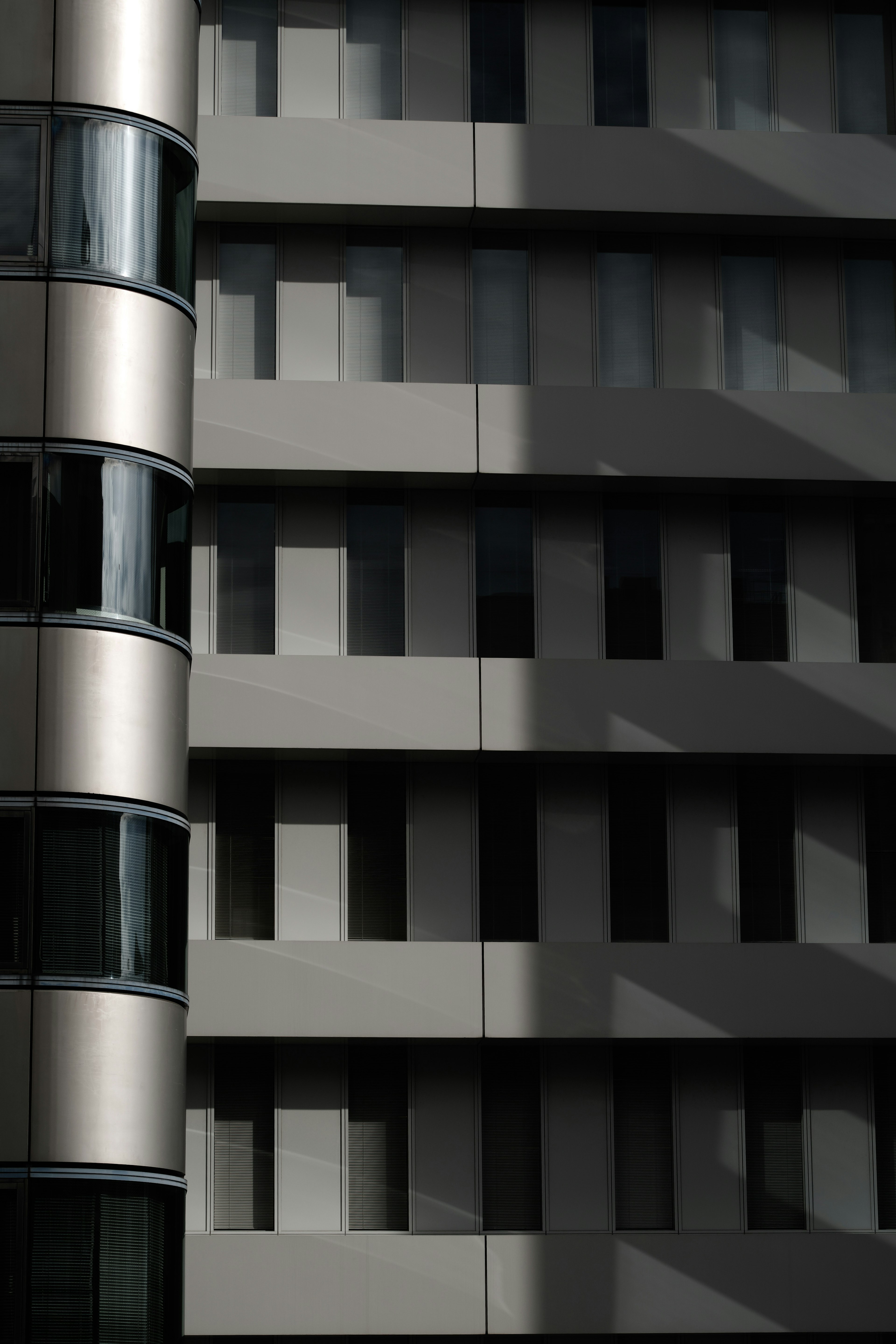 Fachada de edificio moderno con patrones de ventanas geométricas y sombras