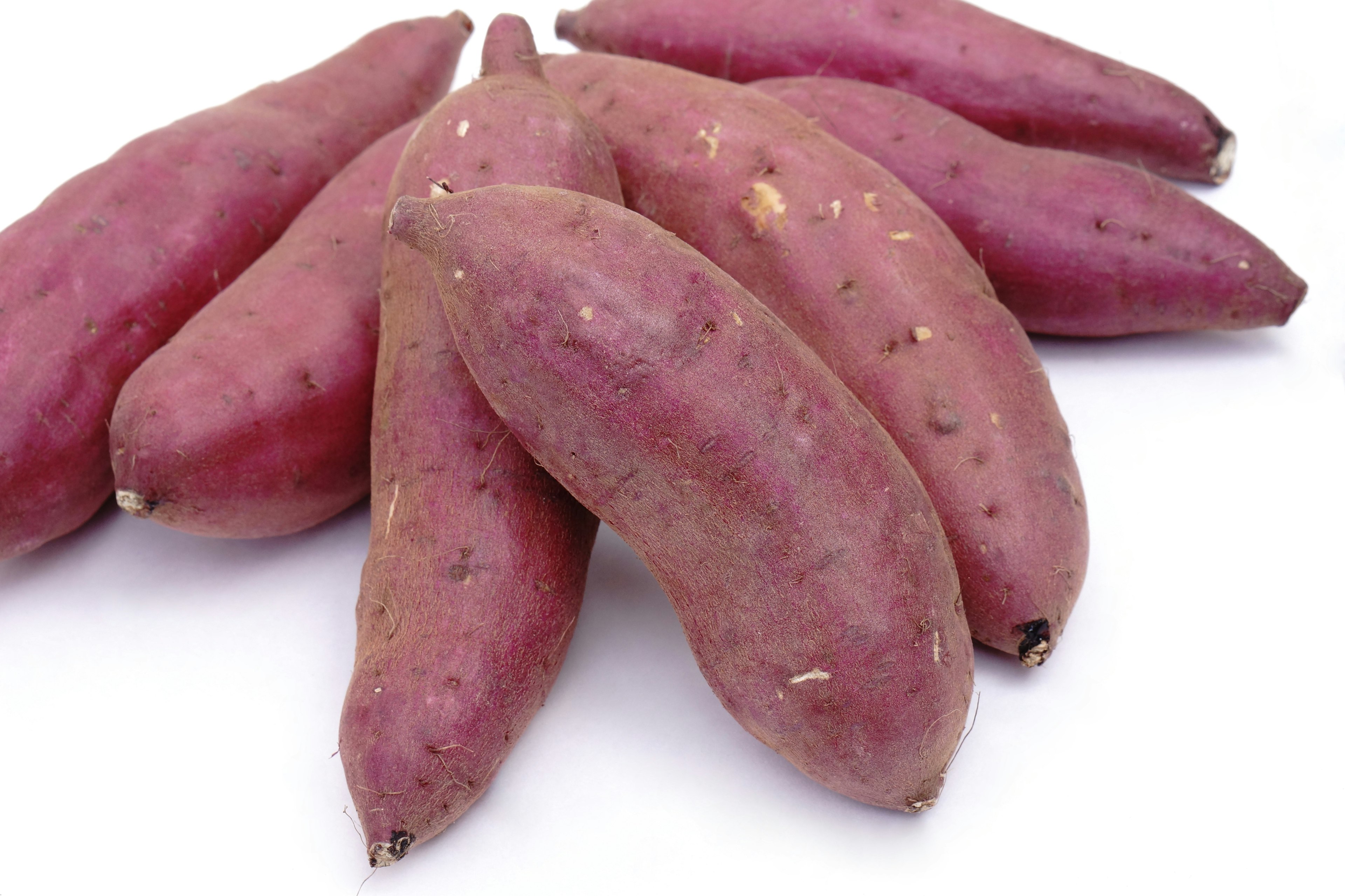 A cluster of purple sweet potatoes on a white background