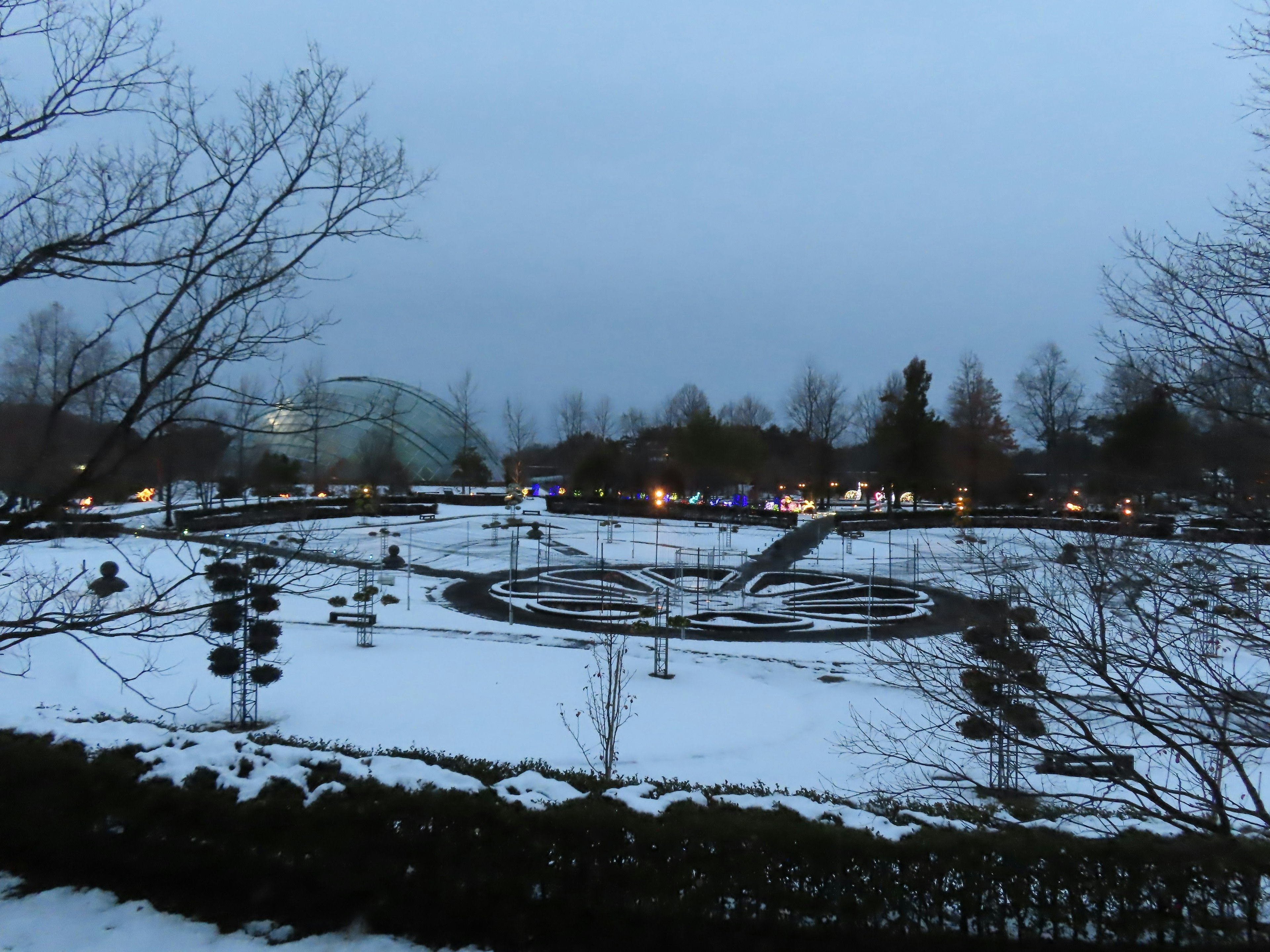 Paysage de parc enneigé avec lumières du soir