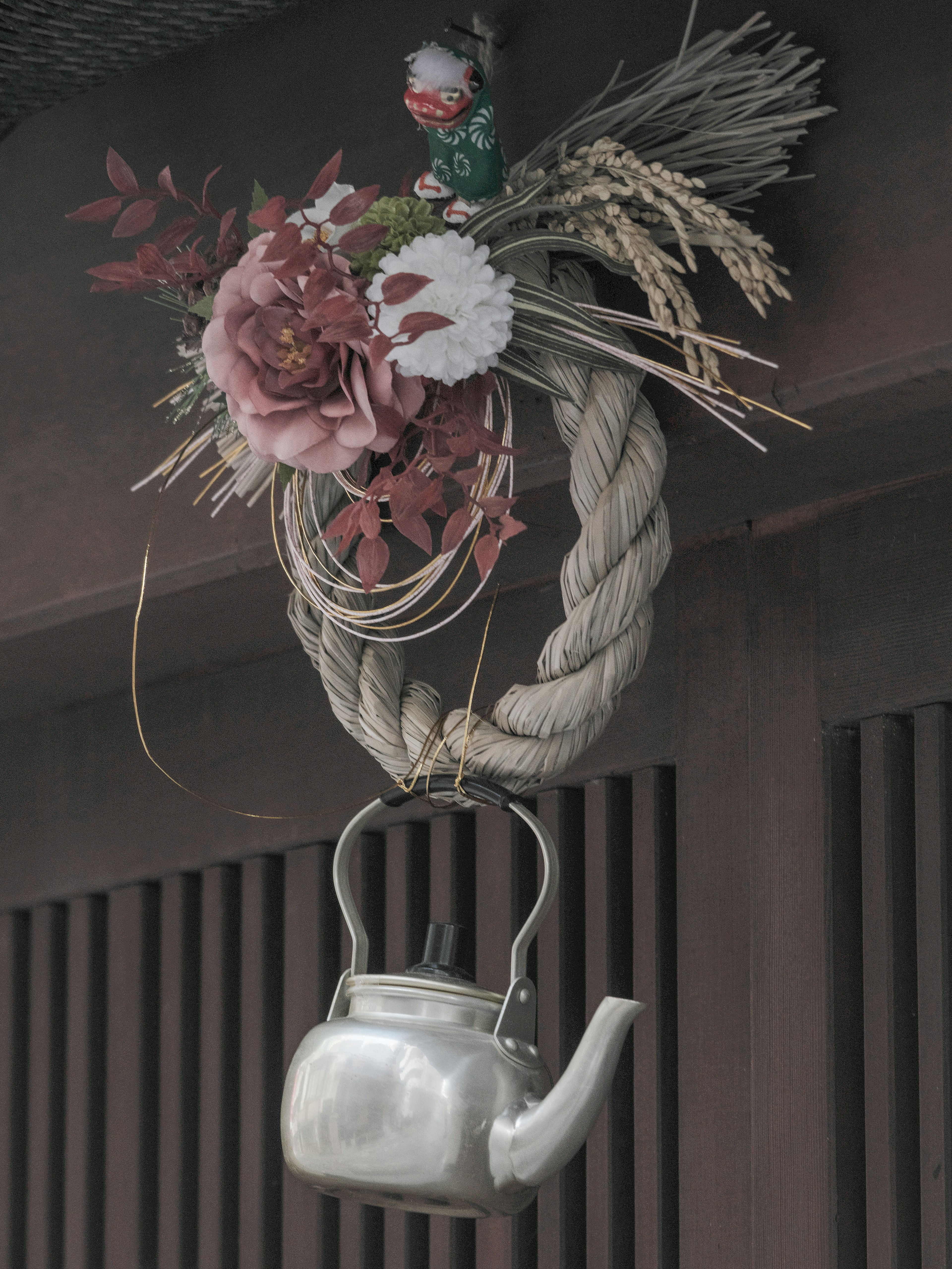 Decorative silver kettle hanging with flowers and rope