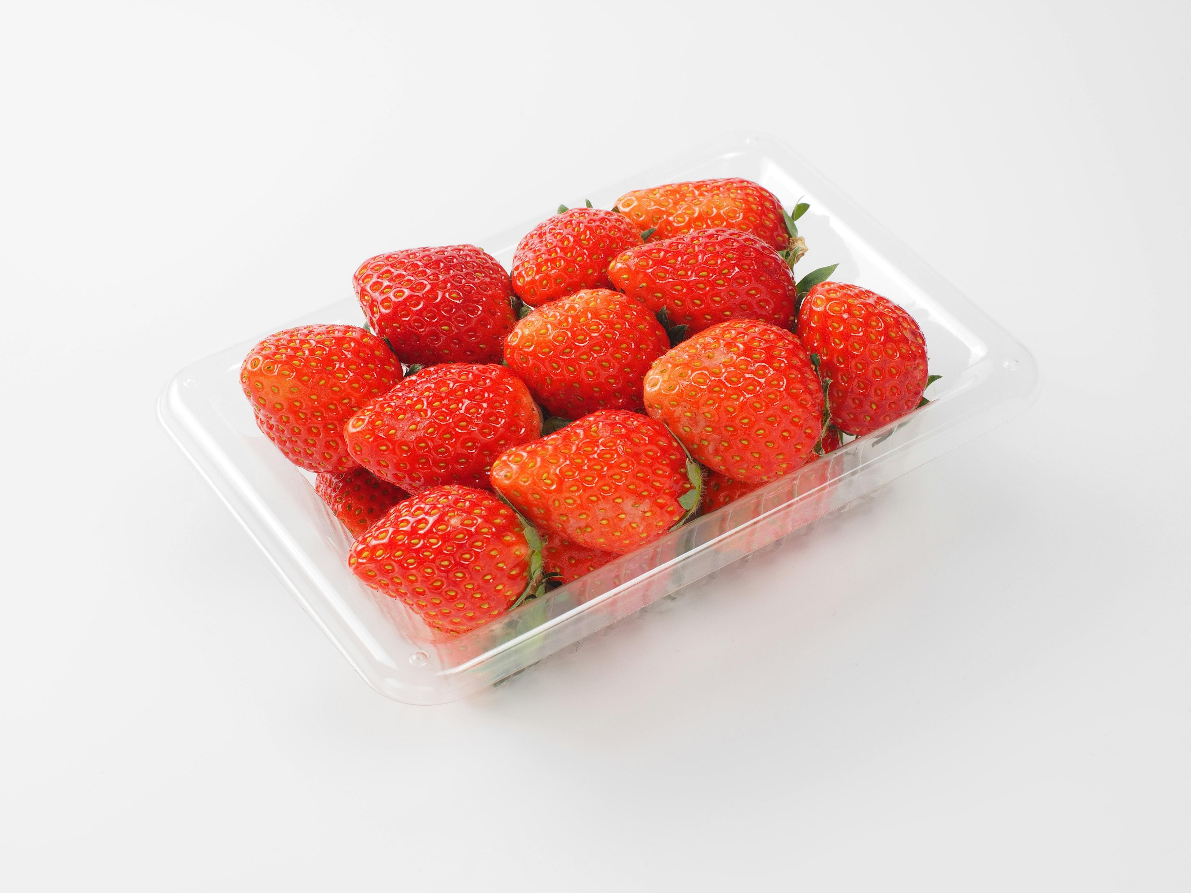 Fresh strawberries arranged in a clear plastic container