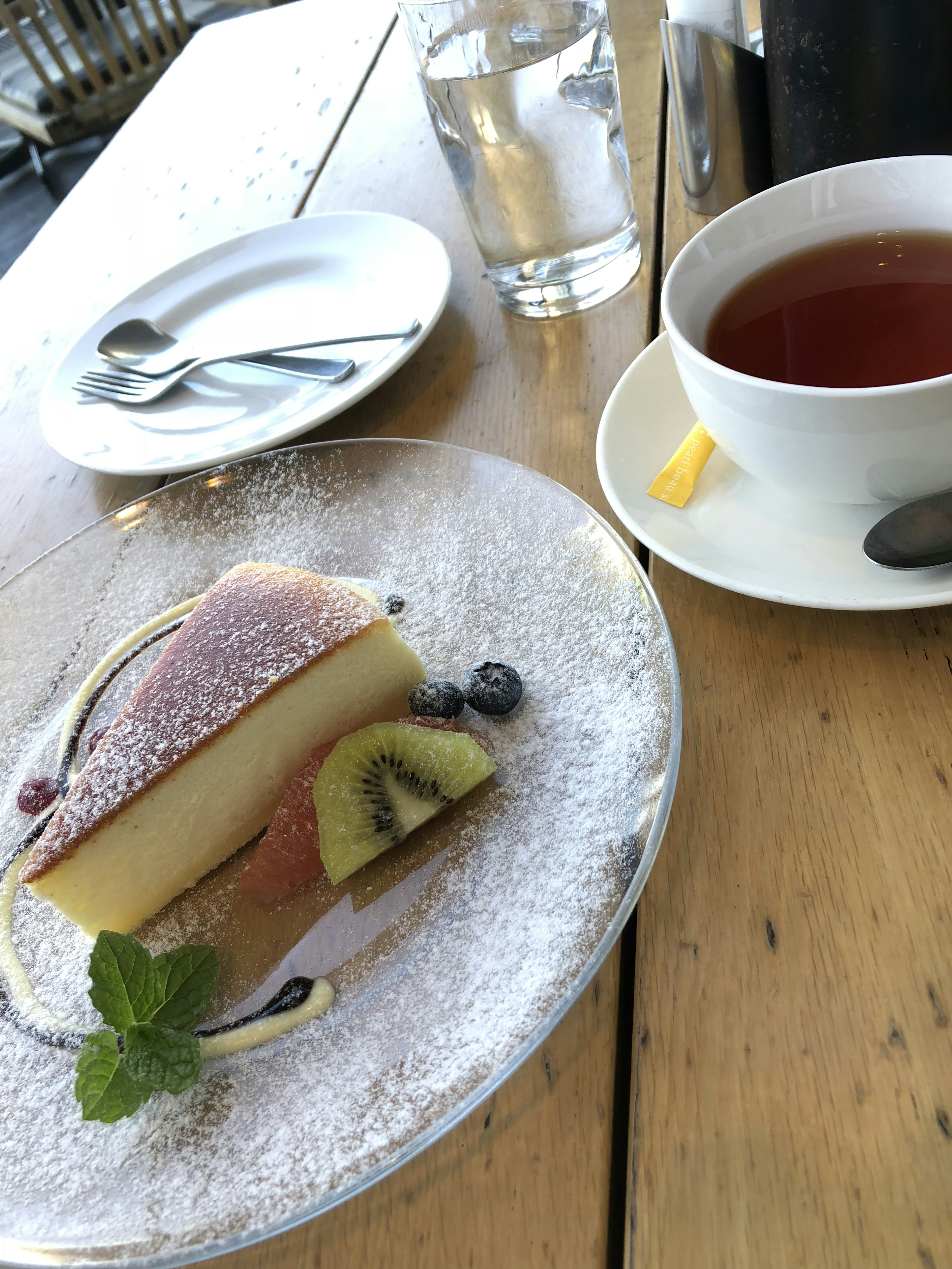 Dessert et thé sur une table en bois avec garniture de fruits et sucre en poudre