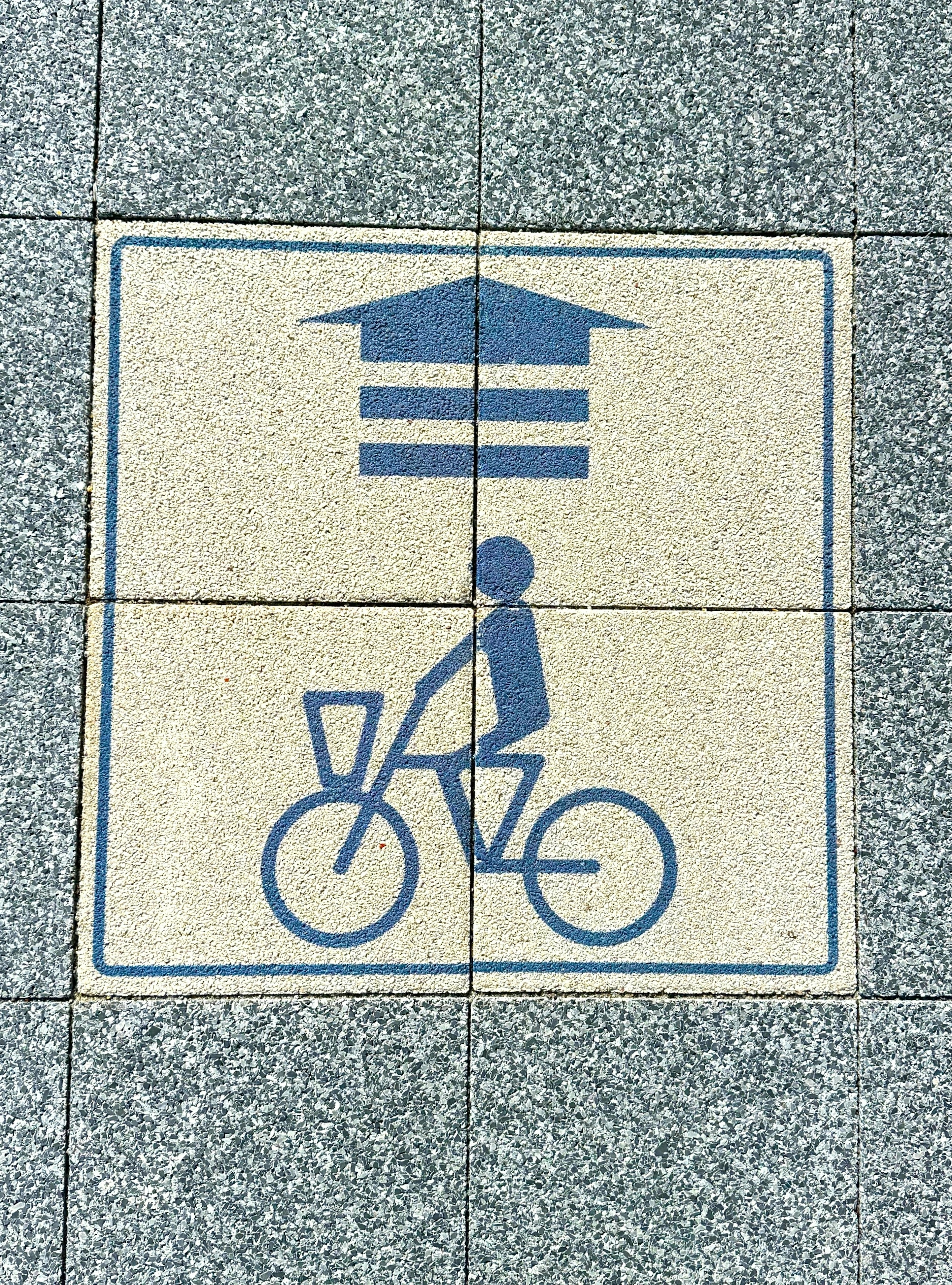 Icono azul de un ciclista con un diseño de techo en una losa