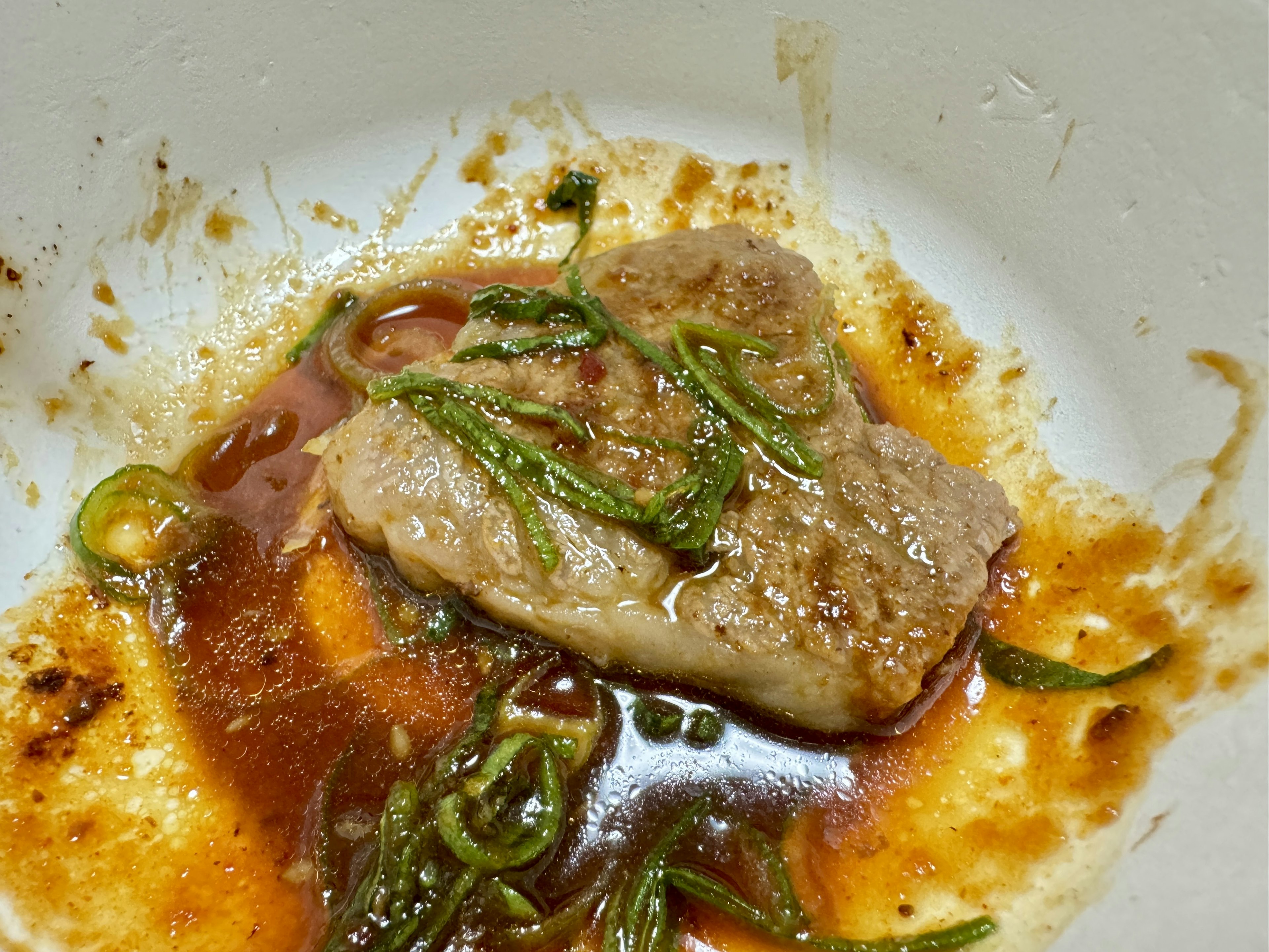 Morceau de viande dans un bol avec sauce aux herbes vertes