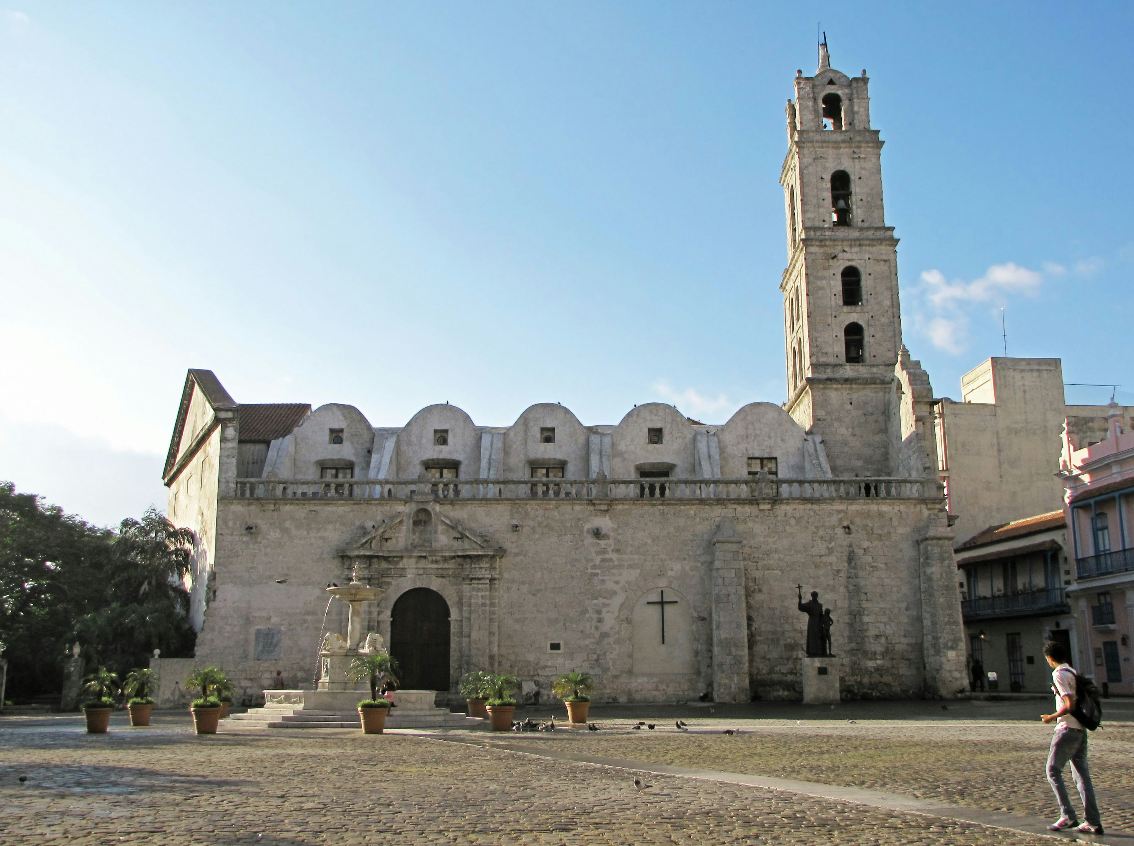 Iglesia de piedra con campanario en un amplio patio