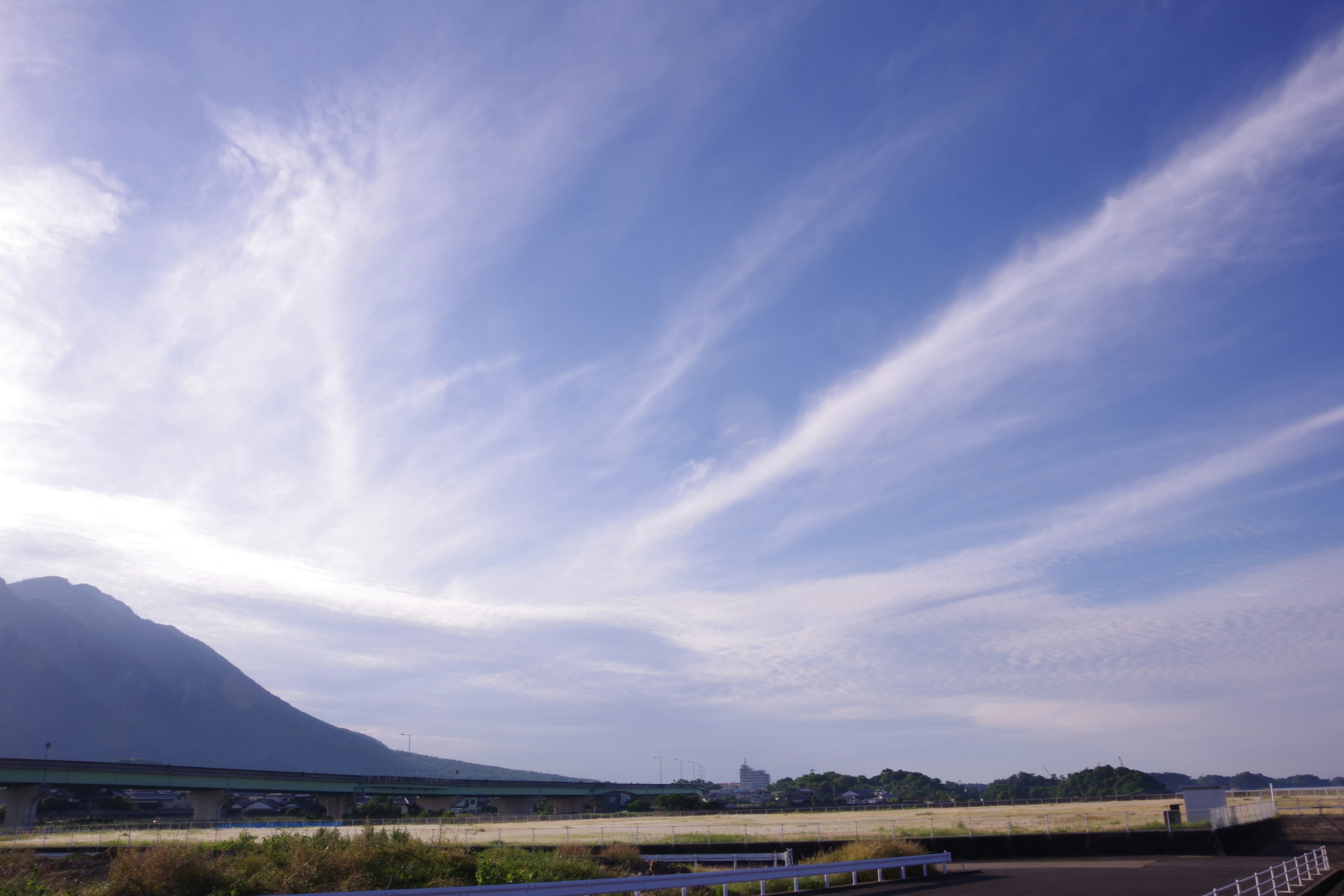 Pemandangan langit biru dan awan tipis di atas pegunungan