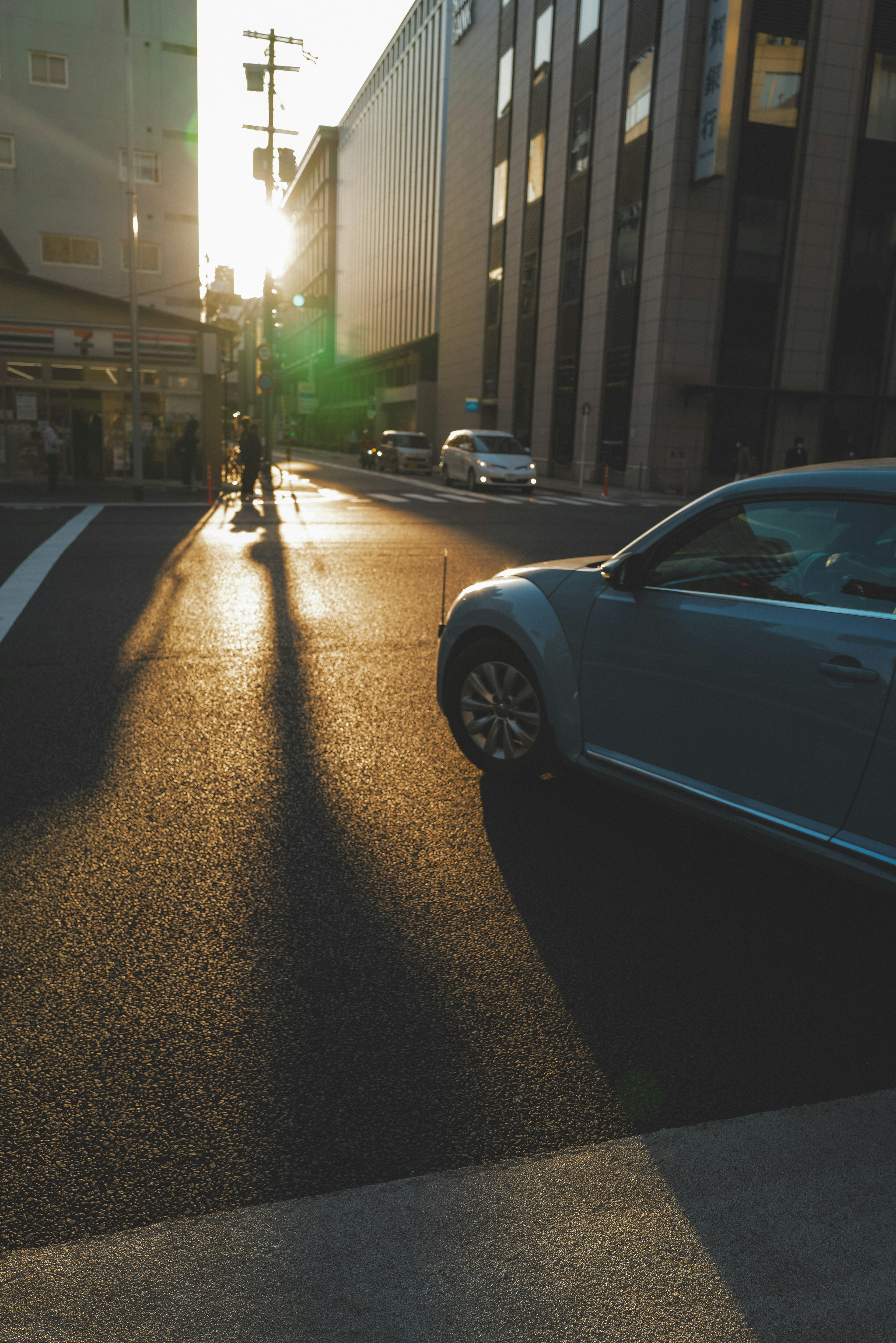 Street corner scene with sunlight shadows car and pedestrian