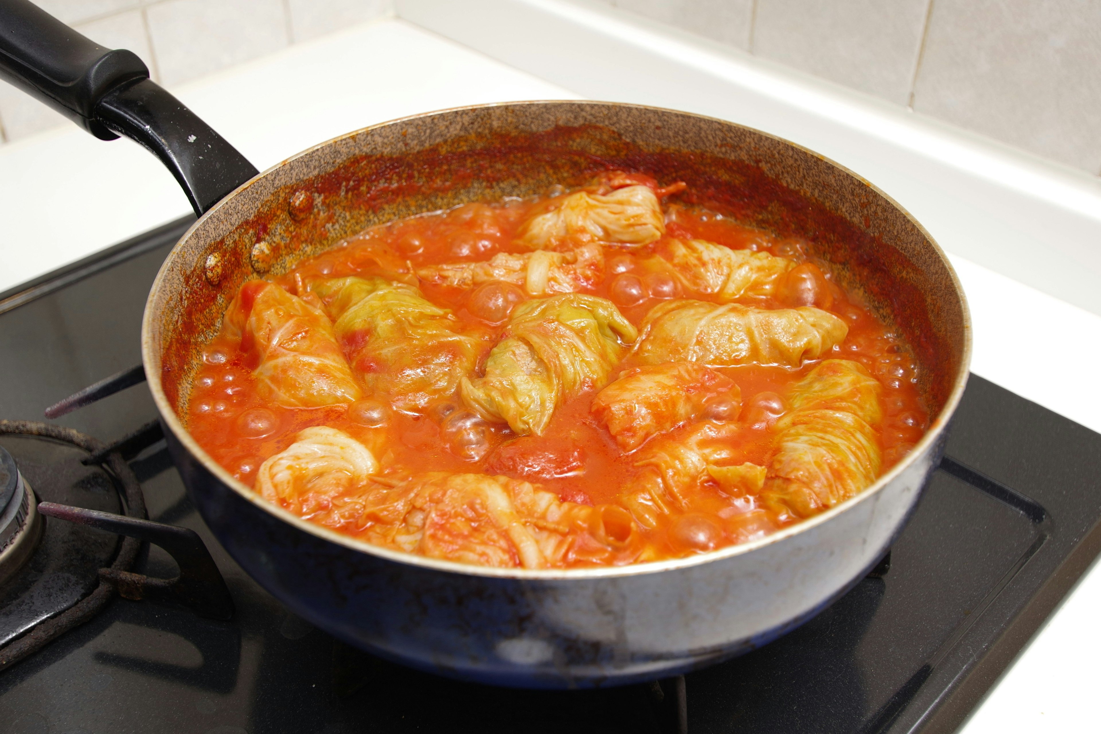 Involtini di cavolo in cottura in salsa di pomodoro in una pentola