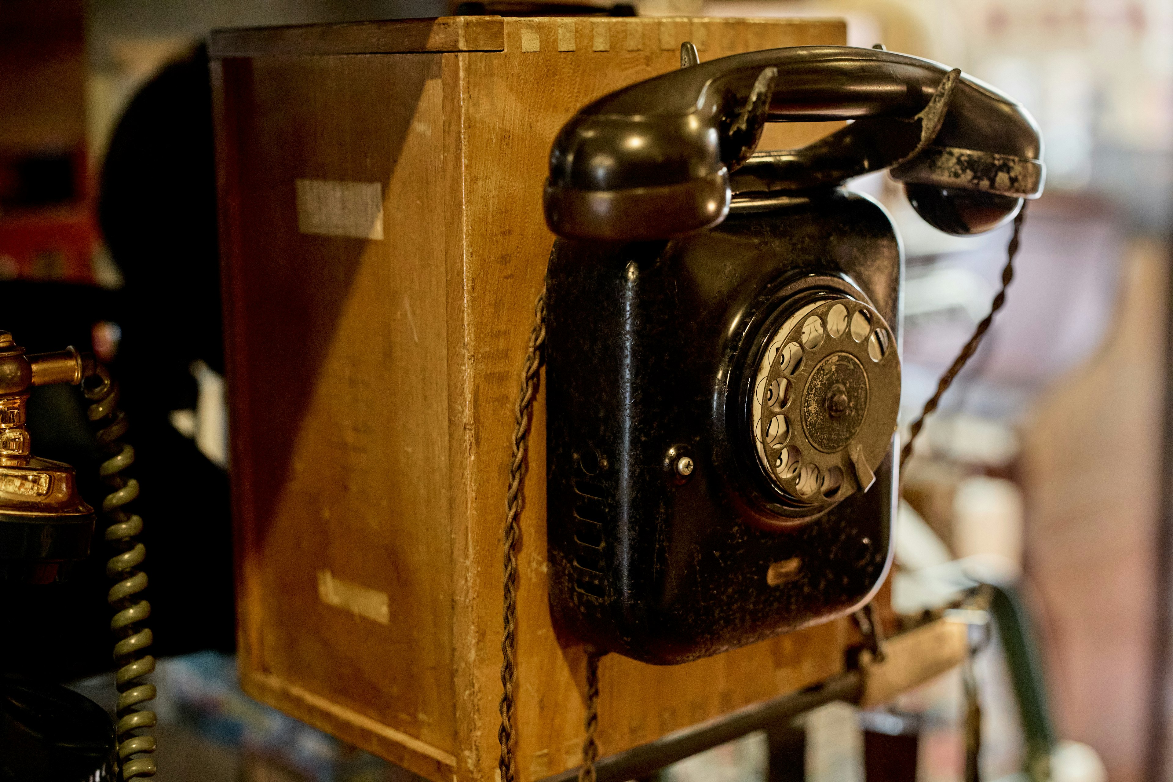 Imagen de un antiguo teléfono negro montado en una caja de madera