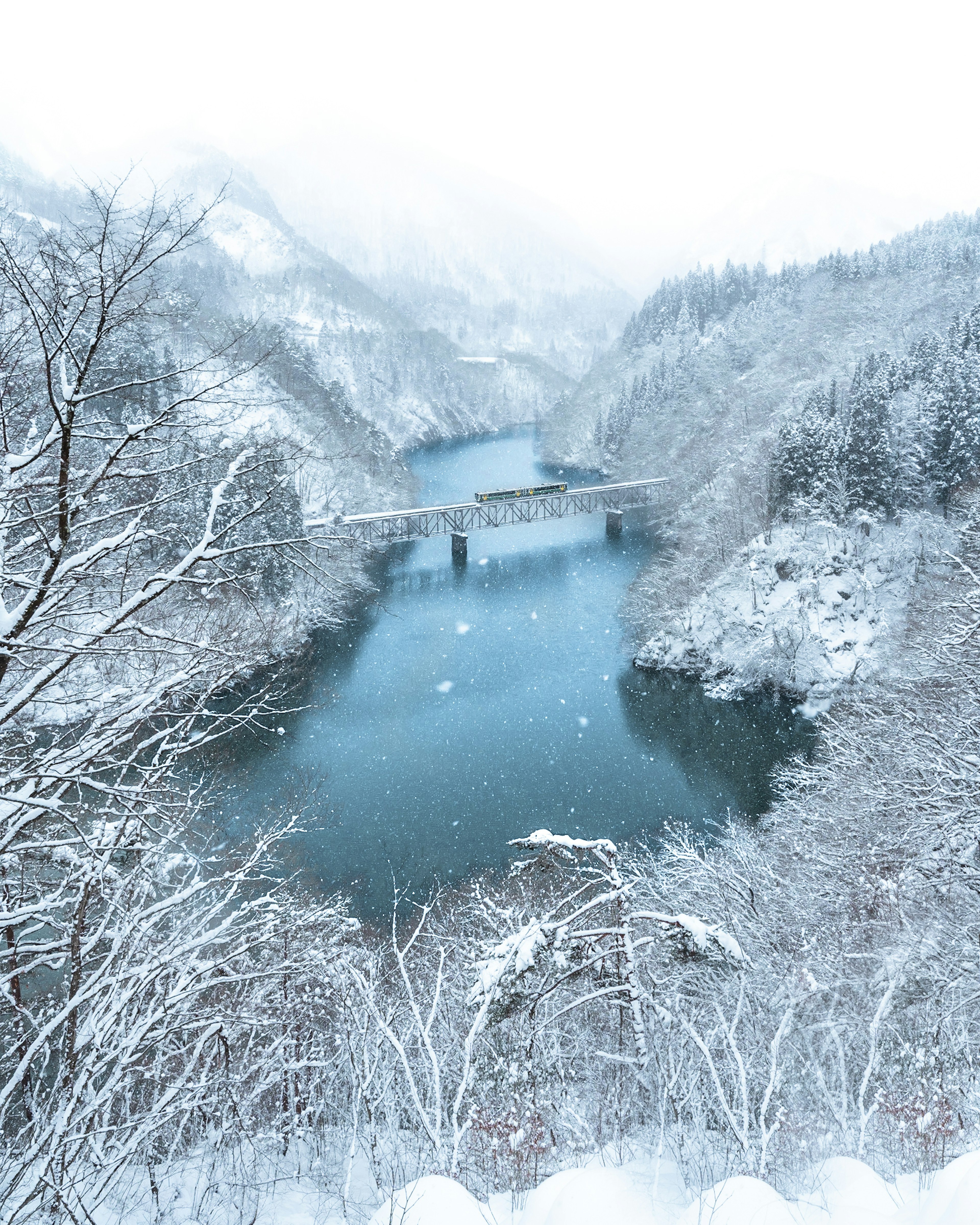 Winter landscape with a snow-covered river and bridge