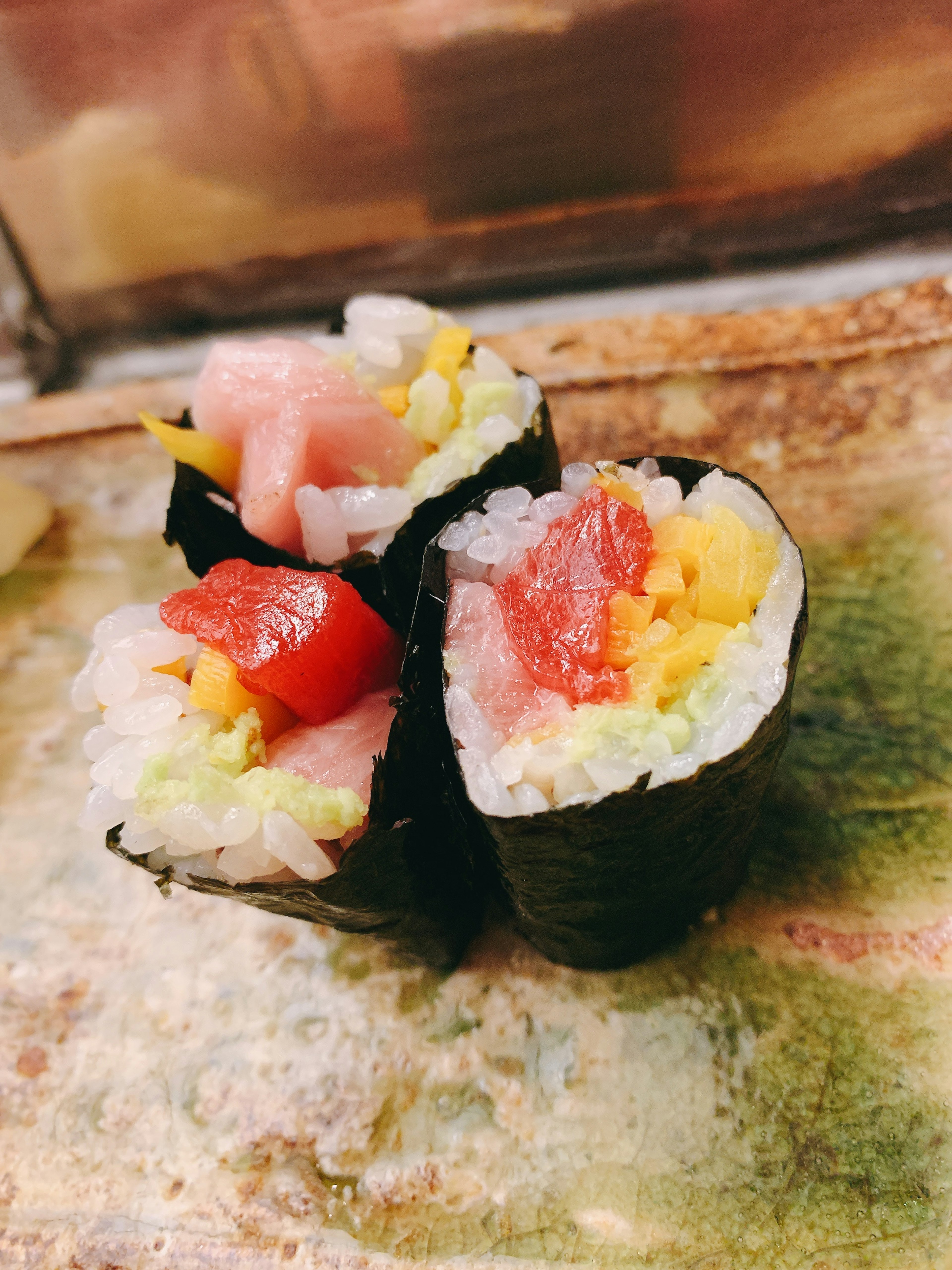 Trois rouleaux de sushi remplis d'ingrédients colorés