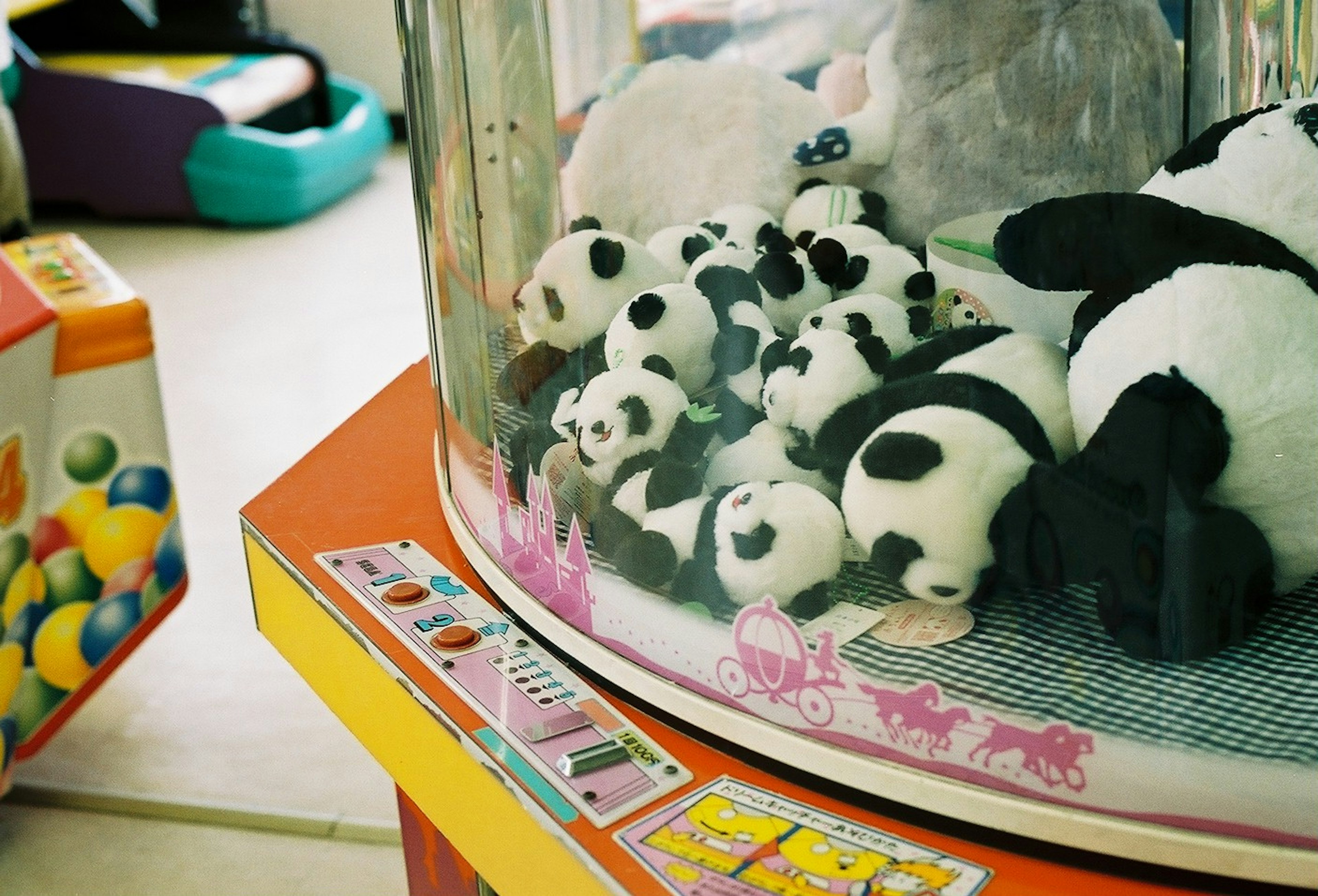 A variety of small panda plush toys inside a claw machine