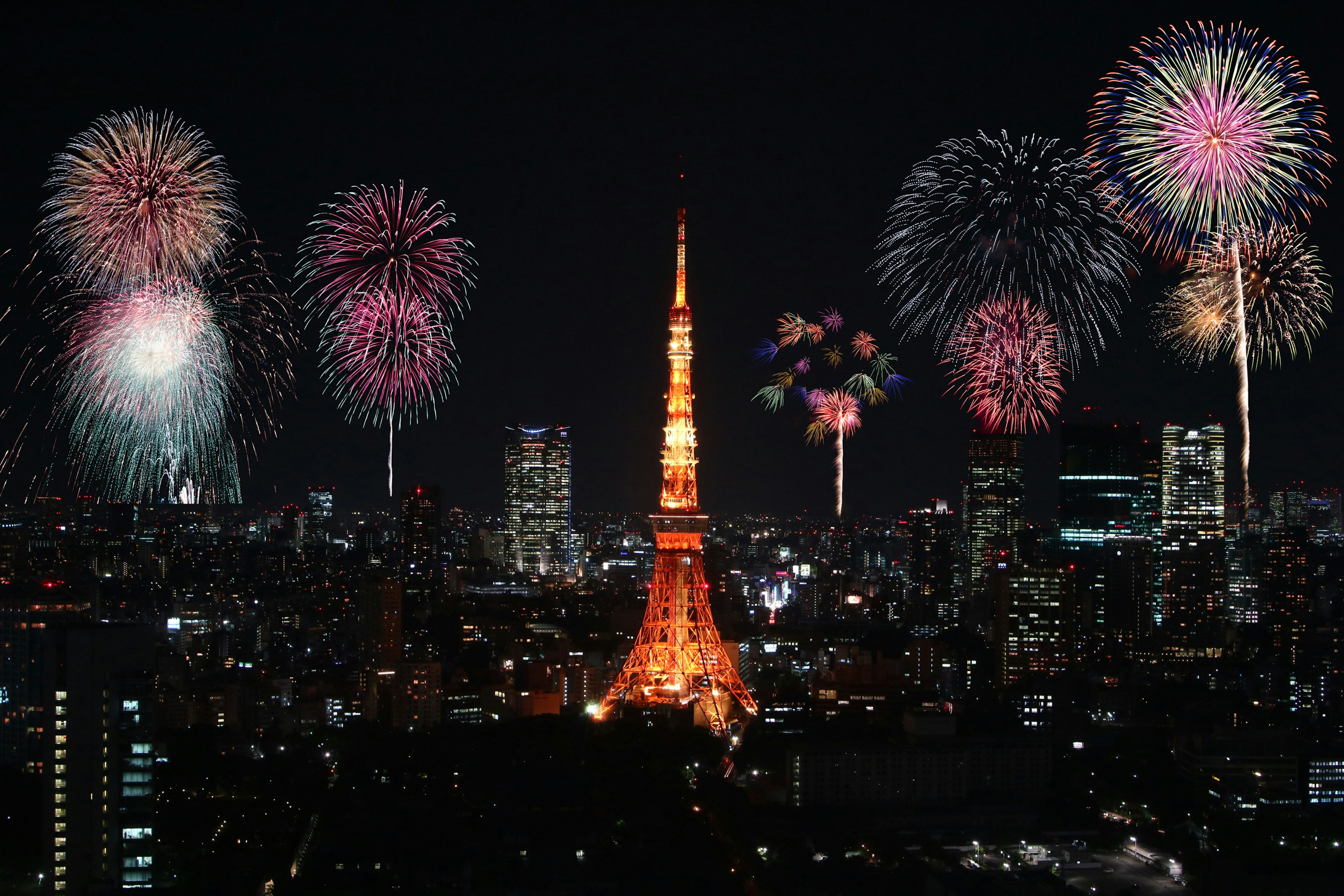 東京タワーと花火の夜景東京の夜空に美しい花火が打ち上げられ東京タワーが輝いている