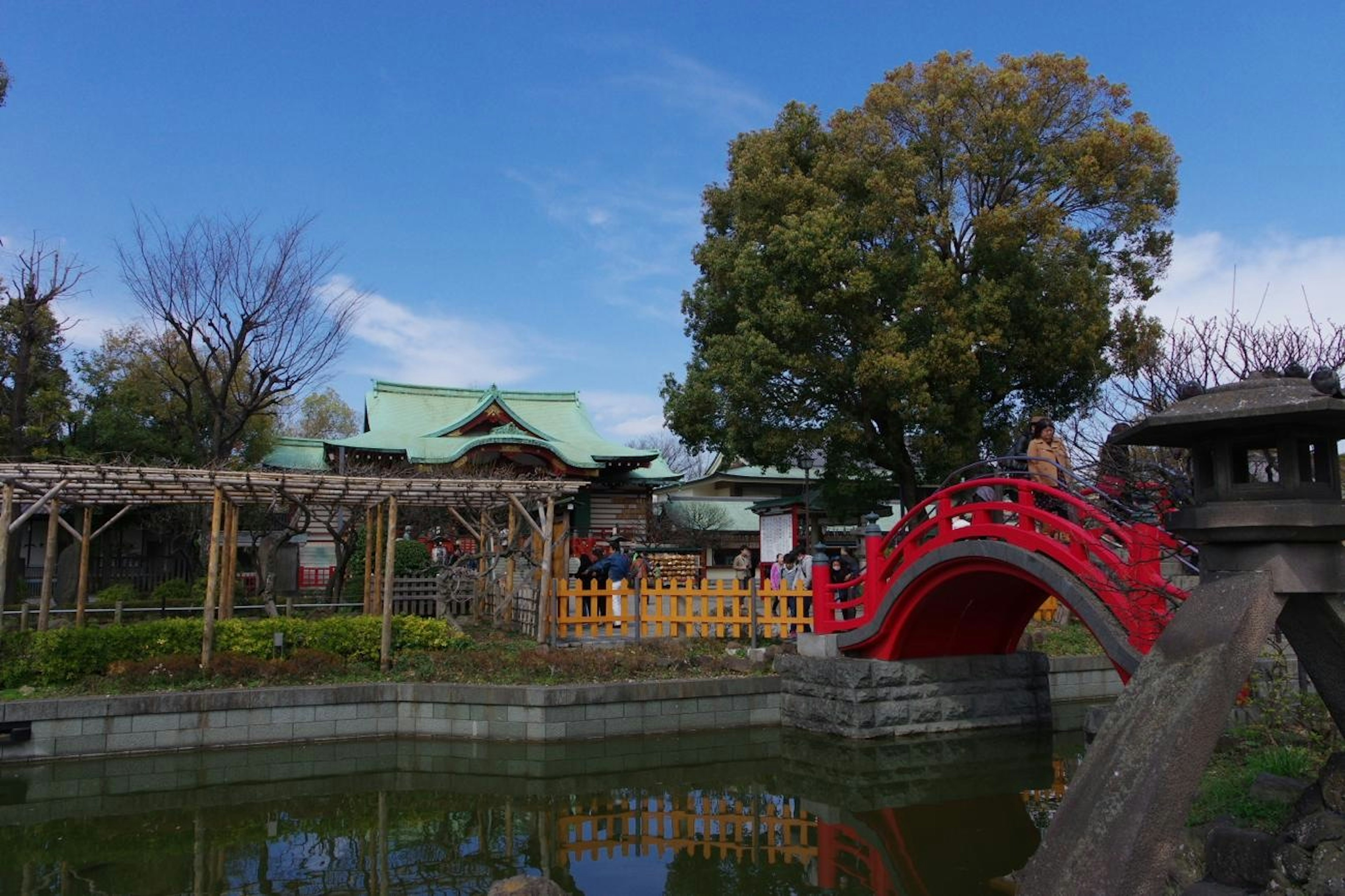 Scenic view of a Japanese garden featuring a red bridge and pond