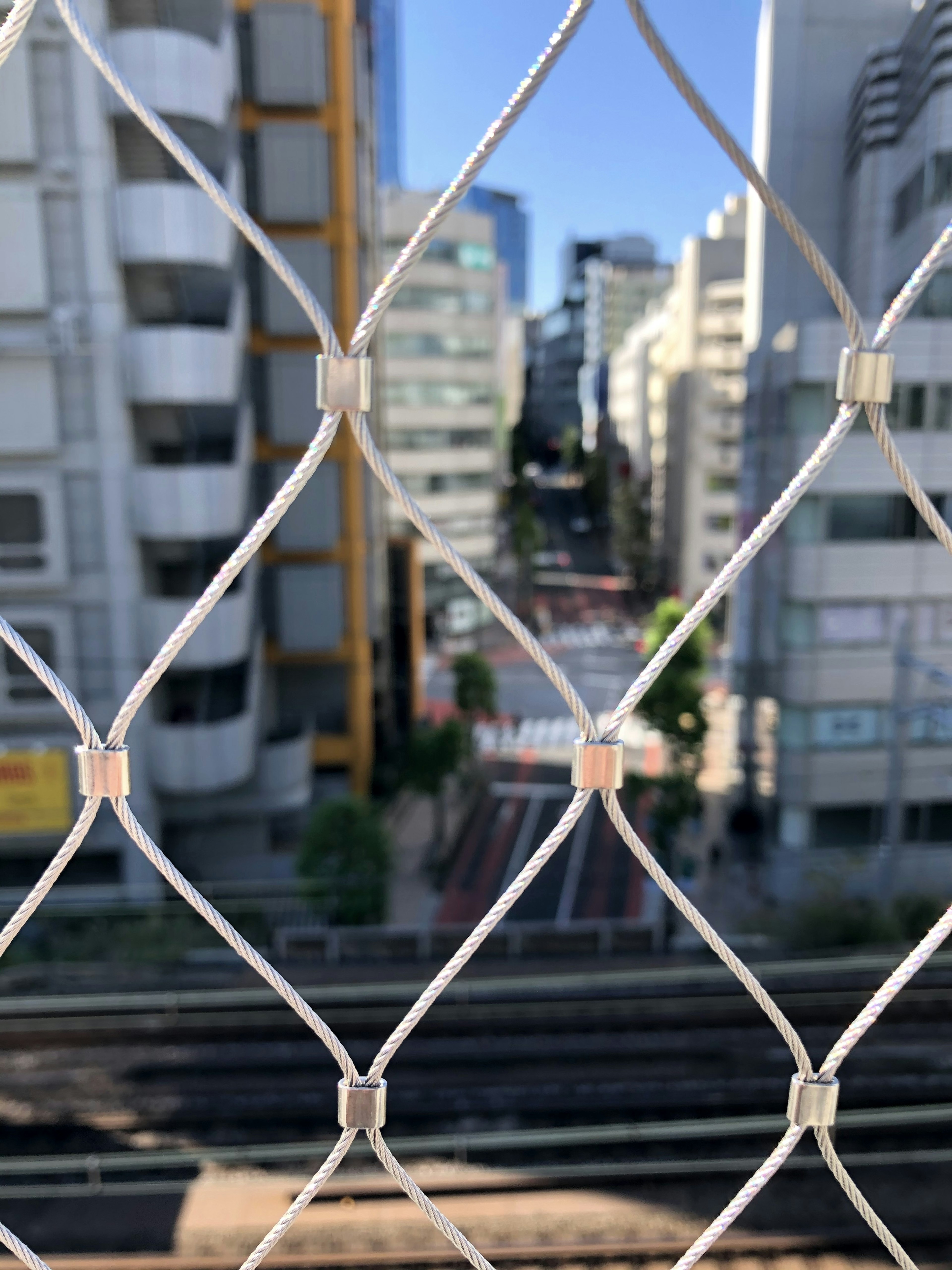 Stadtansicht durch einen weißen Zaun mit Gebäuden und einer Straße