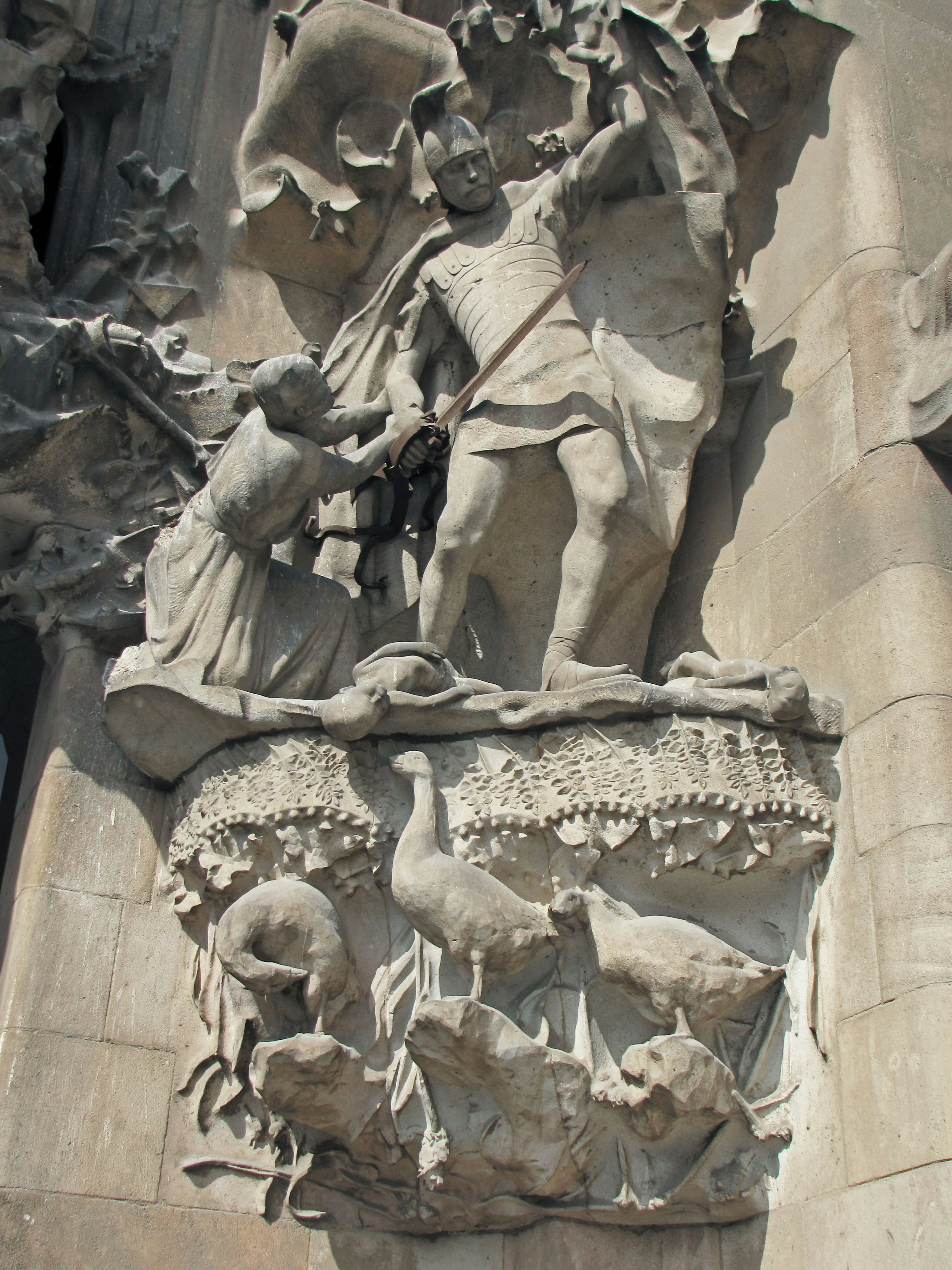 Skulptierte Figur eines Kriegers mit Tieren auf einer Wanddekoration