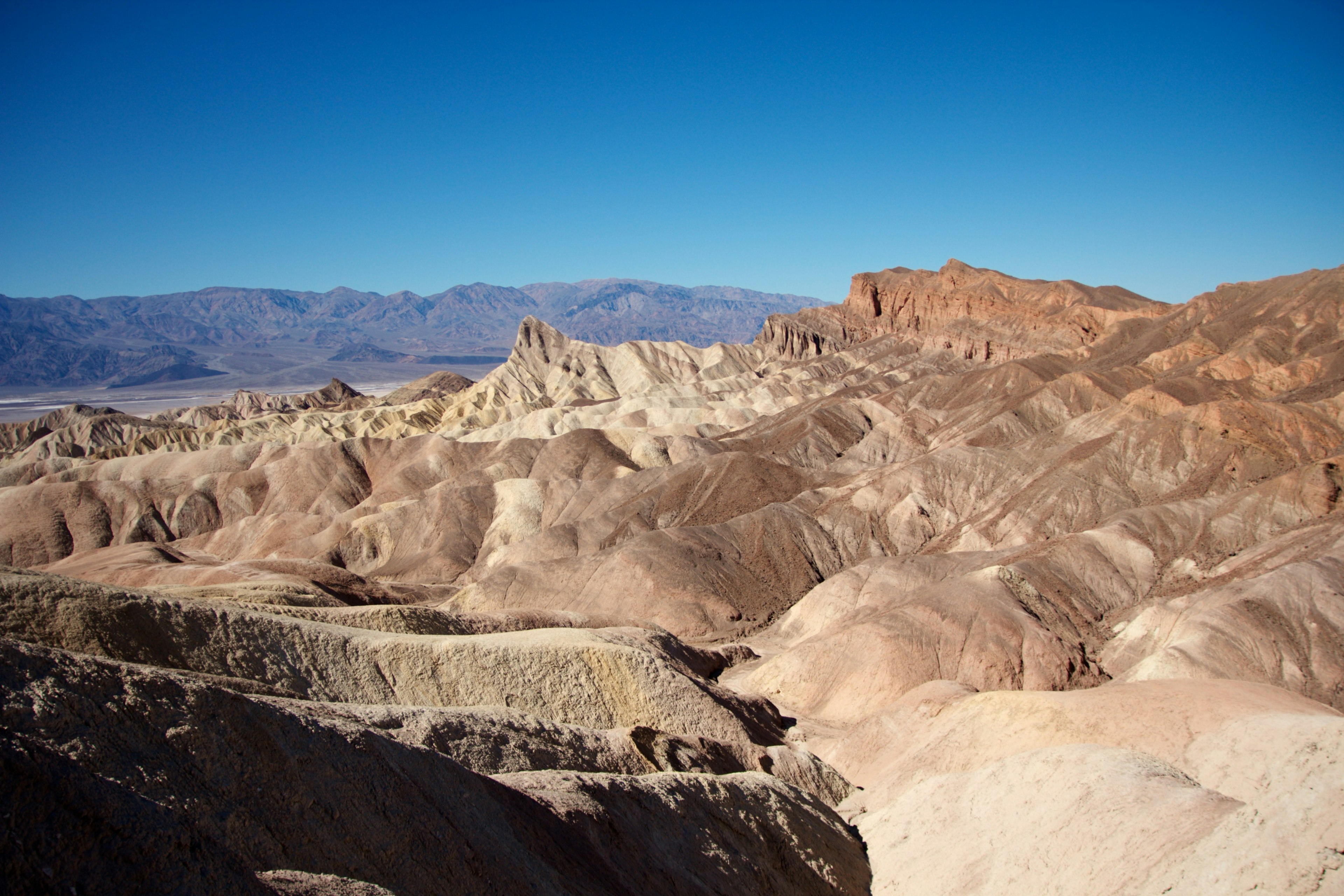 Paysage désertique avec un terrain coloré sous un ciel bleu clair